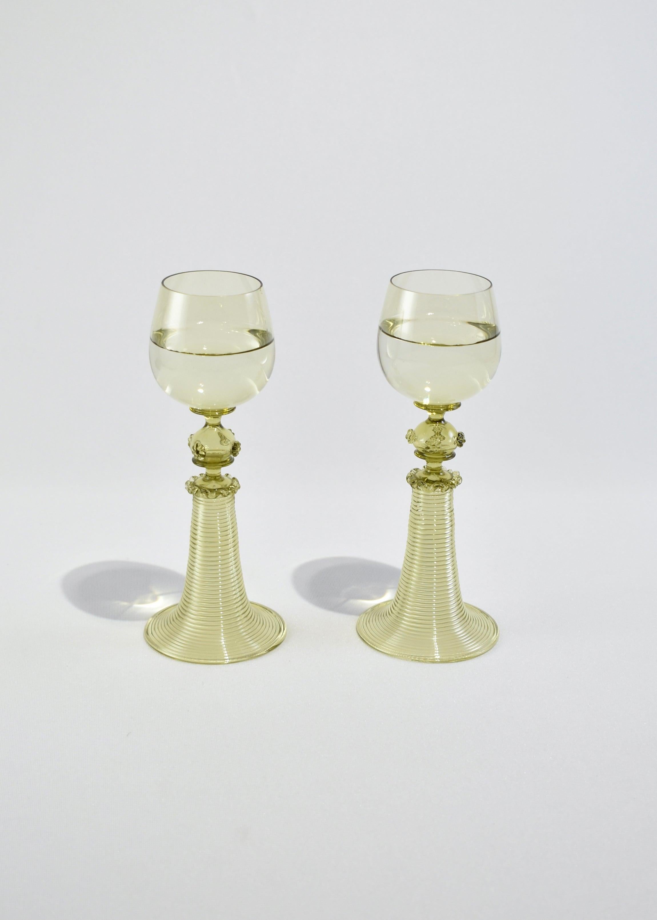 Vintage green blown glass goblet set of two with applied decoration and ribbed stem detail.