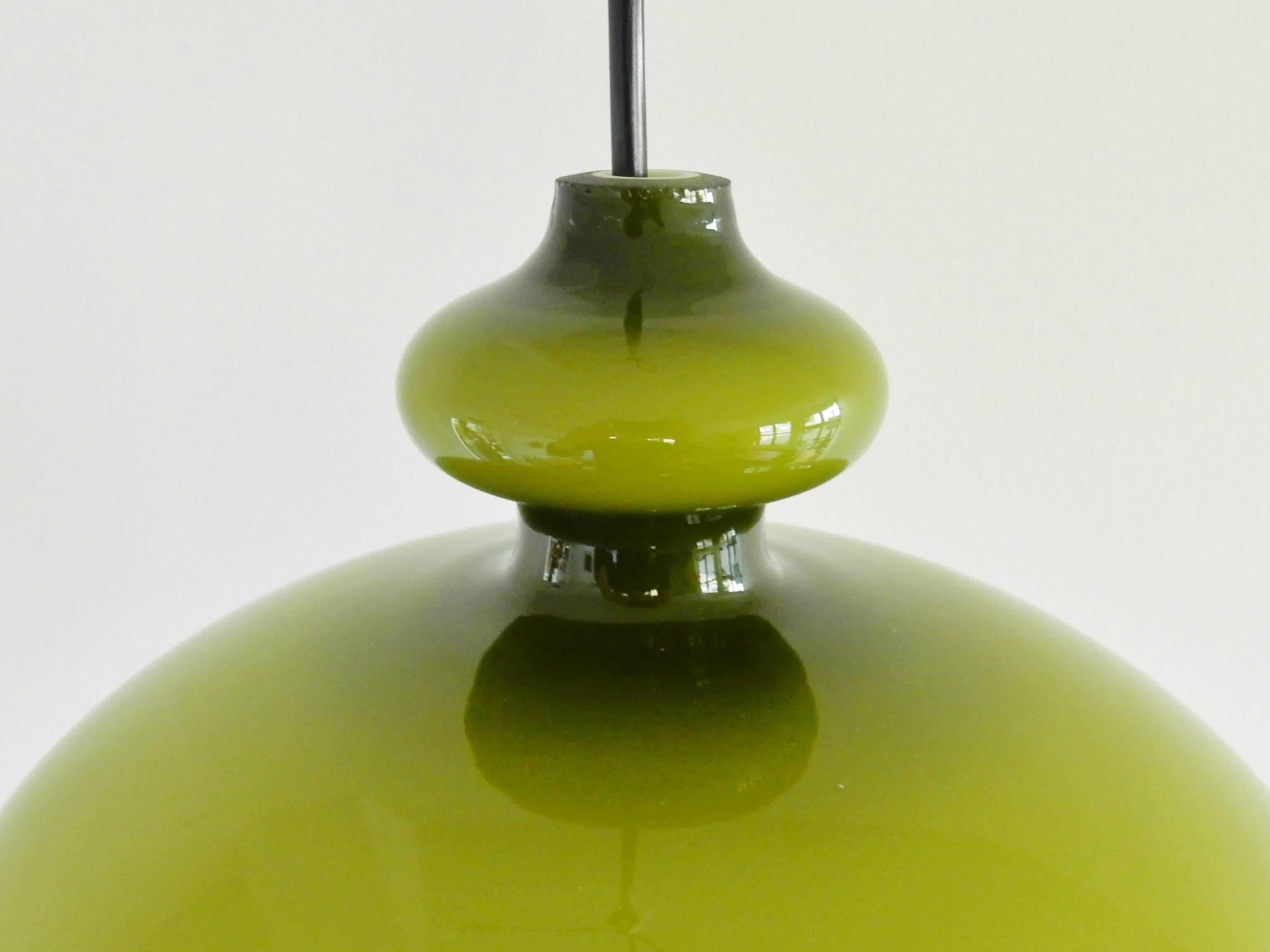 Warm green colored glass pendant lamp with an opaline inside for a beautiful softened light.
The white opaline inner glass has one small chip to the bottom edge. The green glass is in perfect condition.