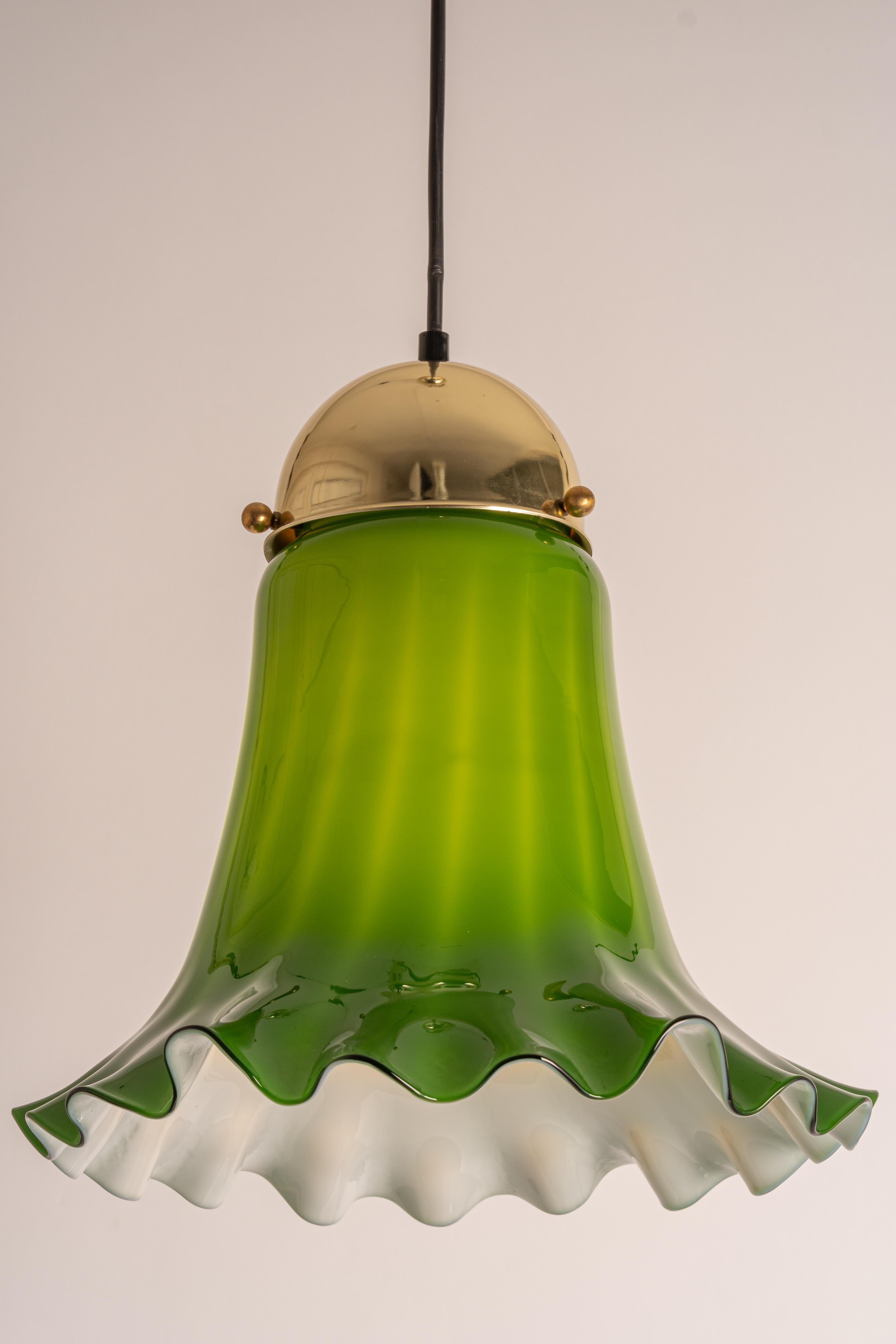 Green glass pendant light by Peill & Putzler, manufactured in Germany, circa the 1970s.

High quality and in very good condition. Cleaned, well-wired, and ready to use. 
The fixture requires 1x E27 Standard bulbs with 100W max
Light bulbs are