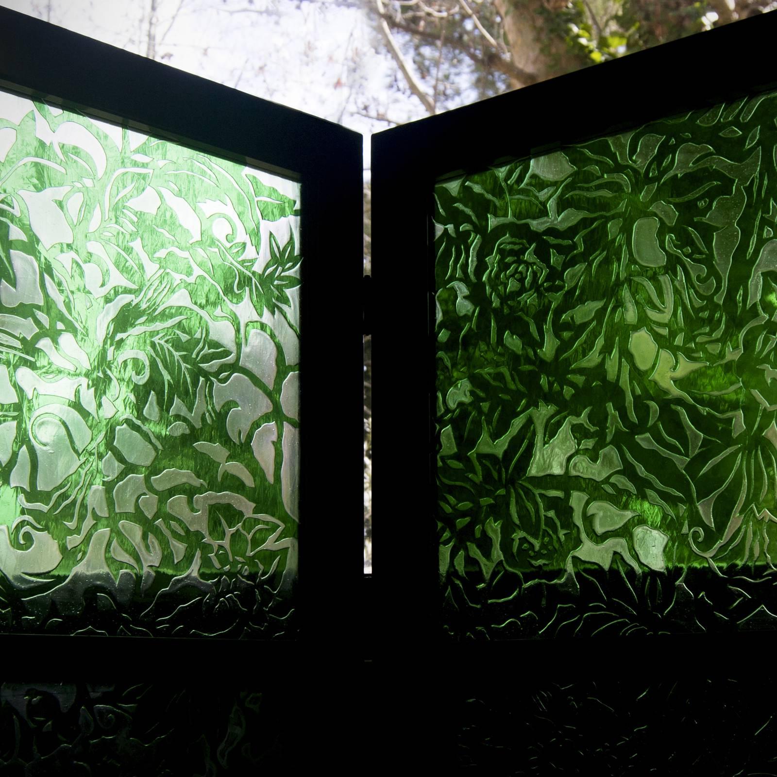 Stunning in its simplicity, this screen is a sophisticated reinterpretation of vintage screens. The wooden frame in black Chinese lacquer supports the distinctive mouth-blown glass panels created by layering clear and green glass. The verdant frond