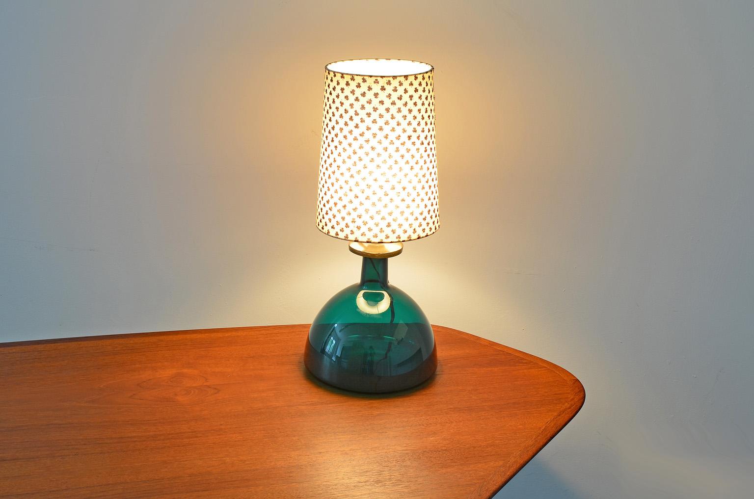 This green table lamp was designed by Per Lutken and produced by Holmegaard in the 1970s. Signed Per Lutken Holmegaard. 
The lamp shade has a crack at the top, see pictures.