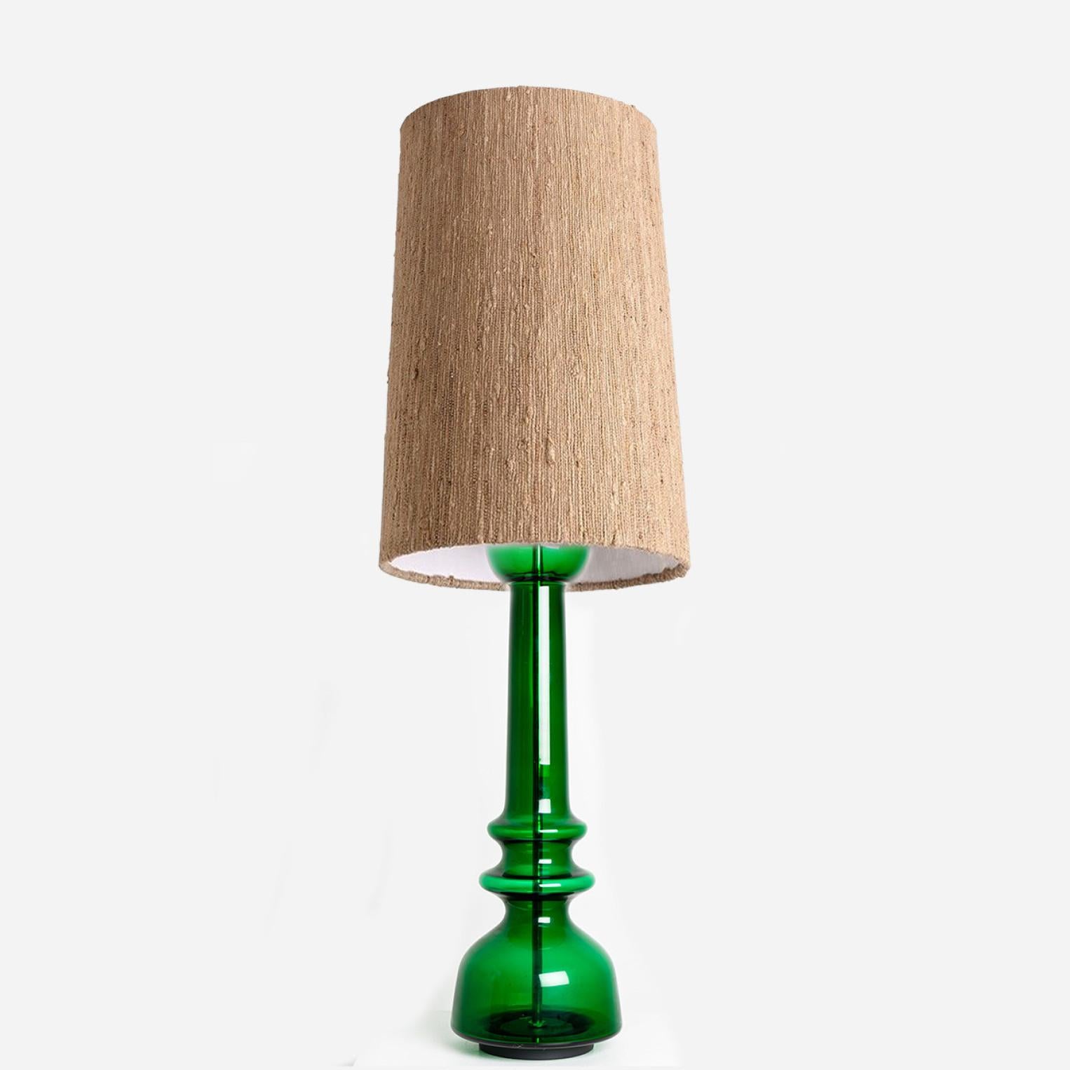 A unique minimalistic timeless design. Designed and manufactured by Doria Leuchten Germany, around 1960.
The glass table lamp features a bright green transparent base with a chrome rod running through the center. Finished with a custom made shade.