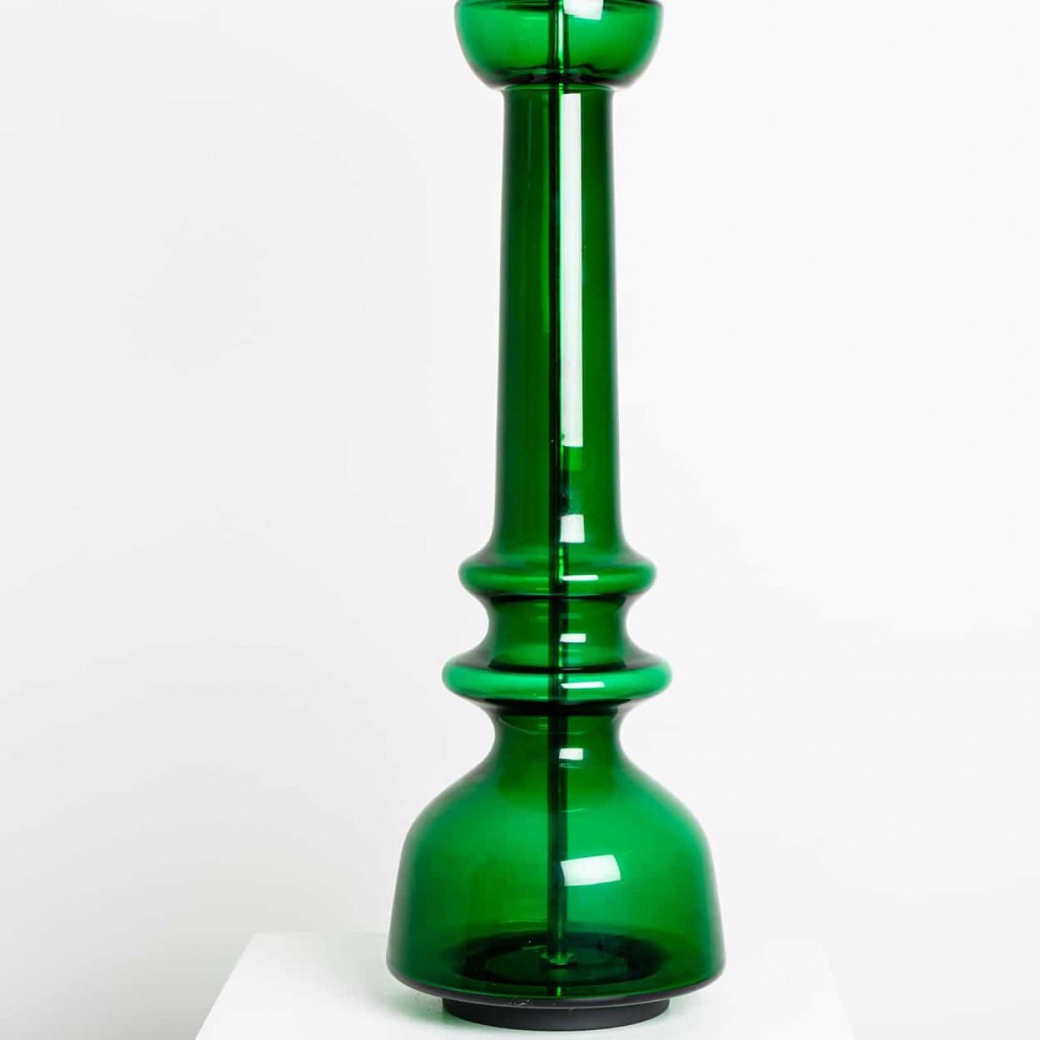 Un diseño único, minimalista y atemporal. Diseñado y fabricado por Doria Leuchten Germany, hacia 1960.
La lámpara de sobremesa de cristal presenta una base transparente de color verde brillante con una varilla cromada que atraviesa el centro.