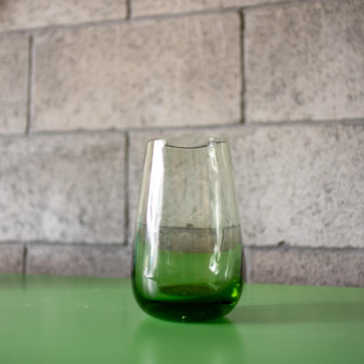 Un raro vaso in vetro soffiato a mano dell'artista francese Claude Morin, attivo a metà del secolo scorso. La morbida tonalità verde si intensifica dolcemente verso la base, creando un delicato gradiente che ne esalta la tranquilla bellezza