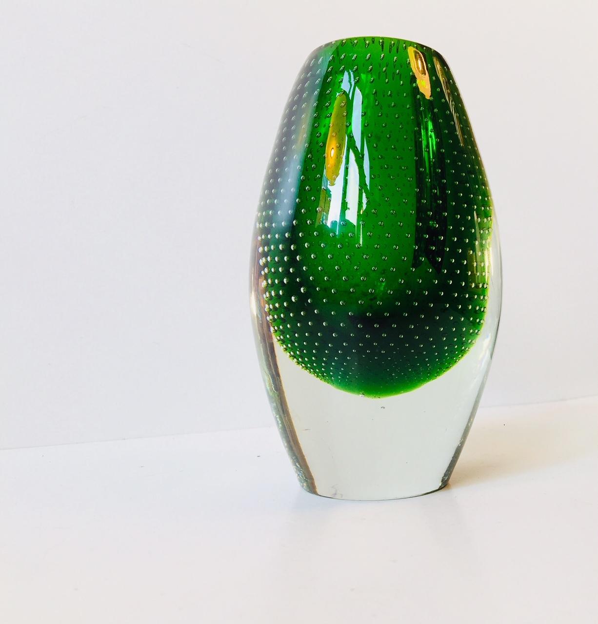 This green signature vase was designed by Finnish designer Gunnel Nyman. It is made of hand blown clear and green glass with air bubbles created using a syringe. It was manufactured at Nuutajarvi Lasi Oy during the late 1940s. The vase is not