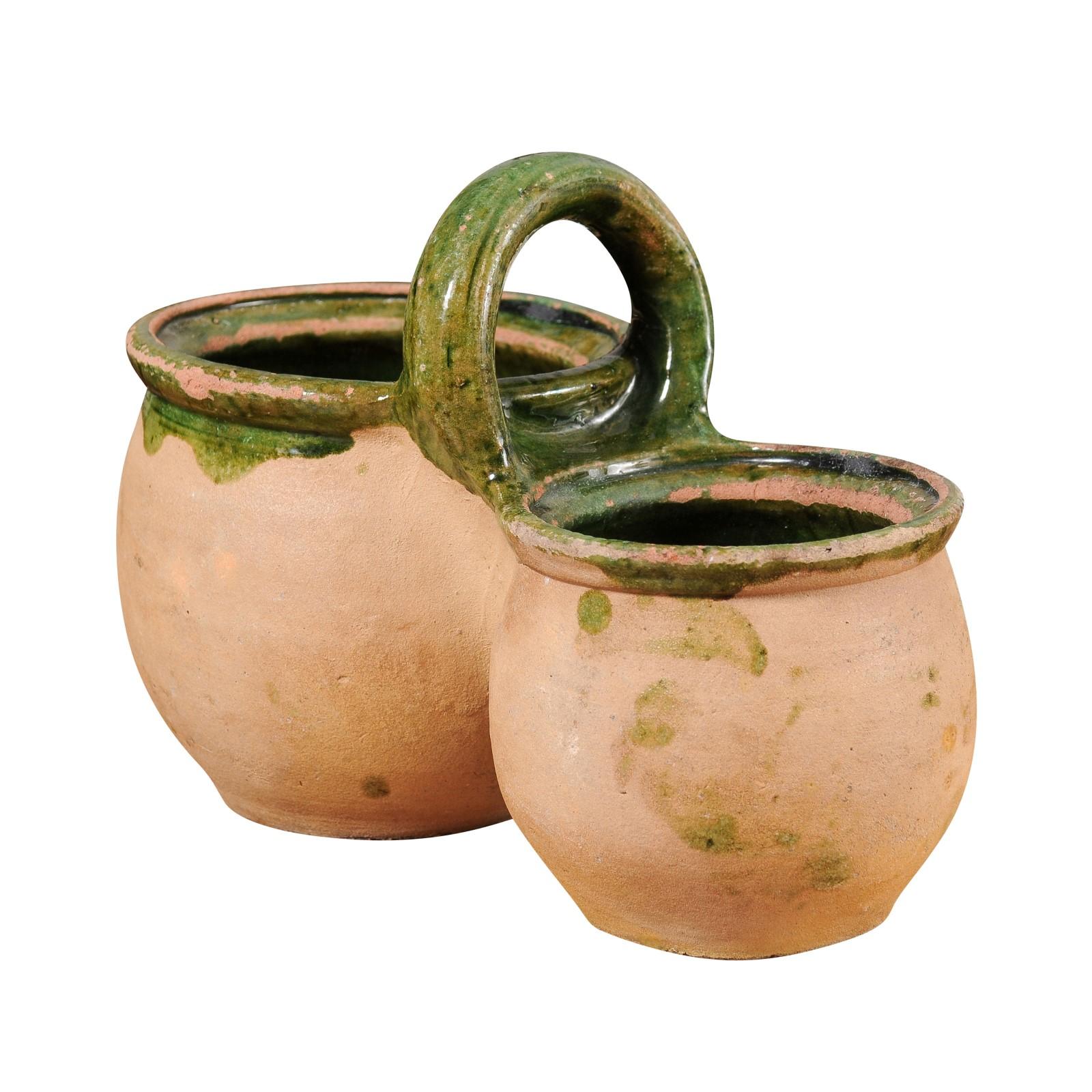 A French pottery shepherd's lunch holder from the 19th century with green glaze, two bowls and large handle. This 19th-century French pottery shepherd's lunch holder, known as a 