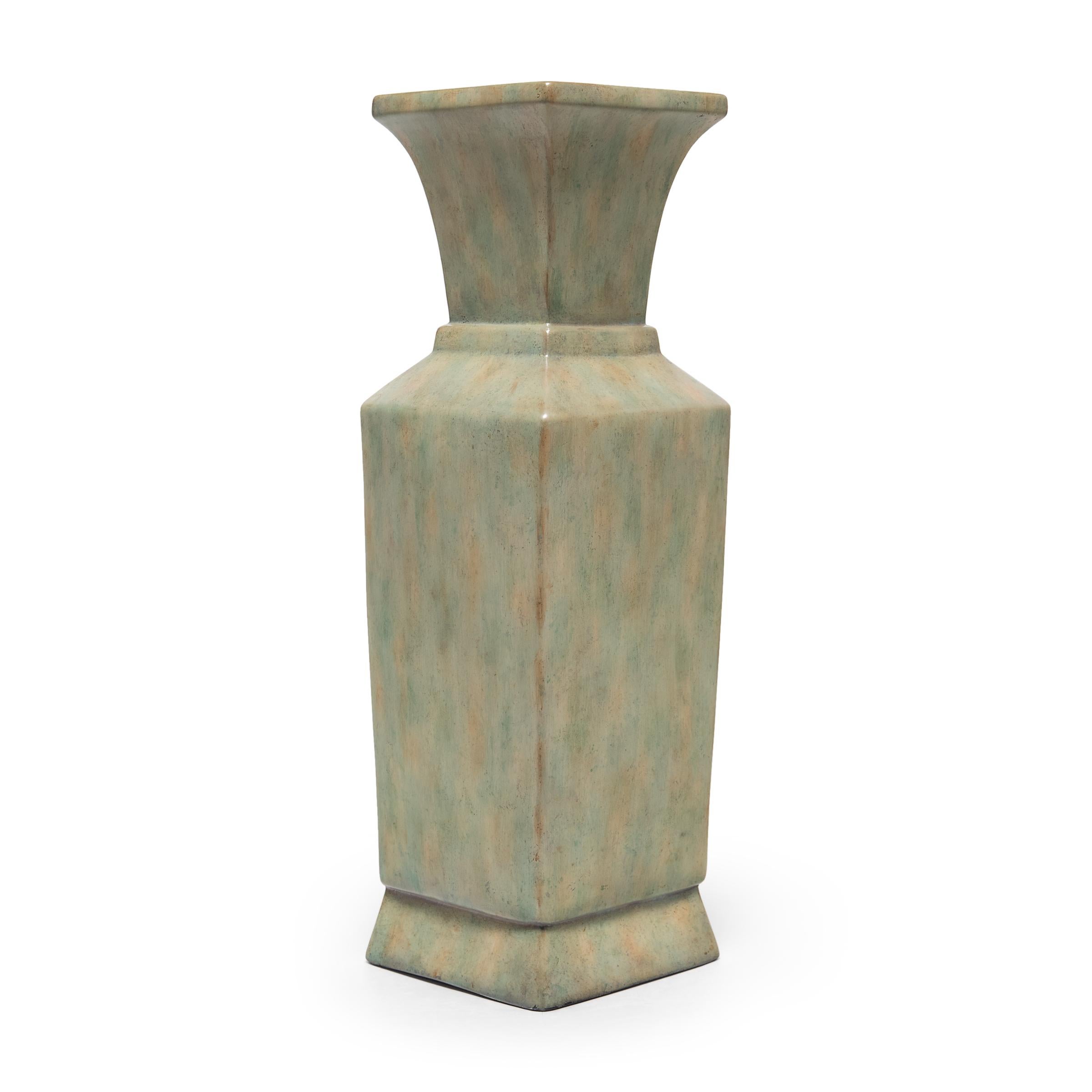 A contemporary iteration of the classic Chinese phoenix-tail vase form, this tall porcelain urn by interior design house Maitland-Smith features a square body with angular shoulders and a flared top. A mottled glaze coats the exterior in a palette