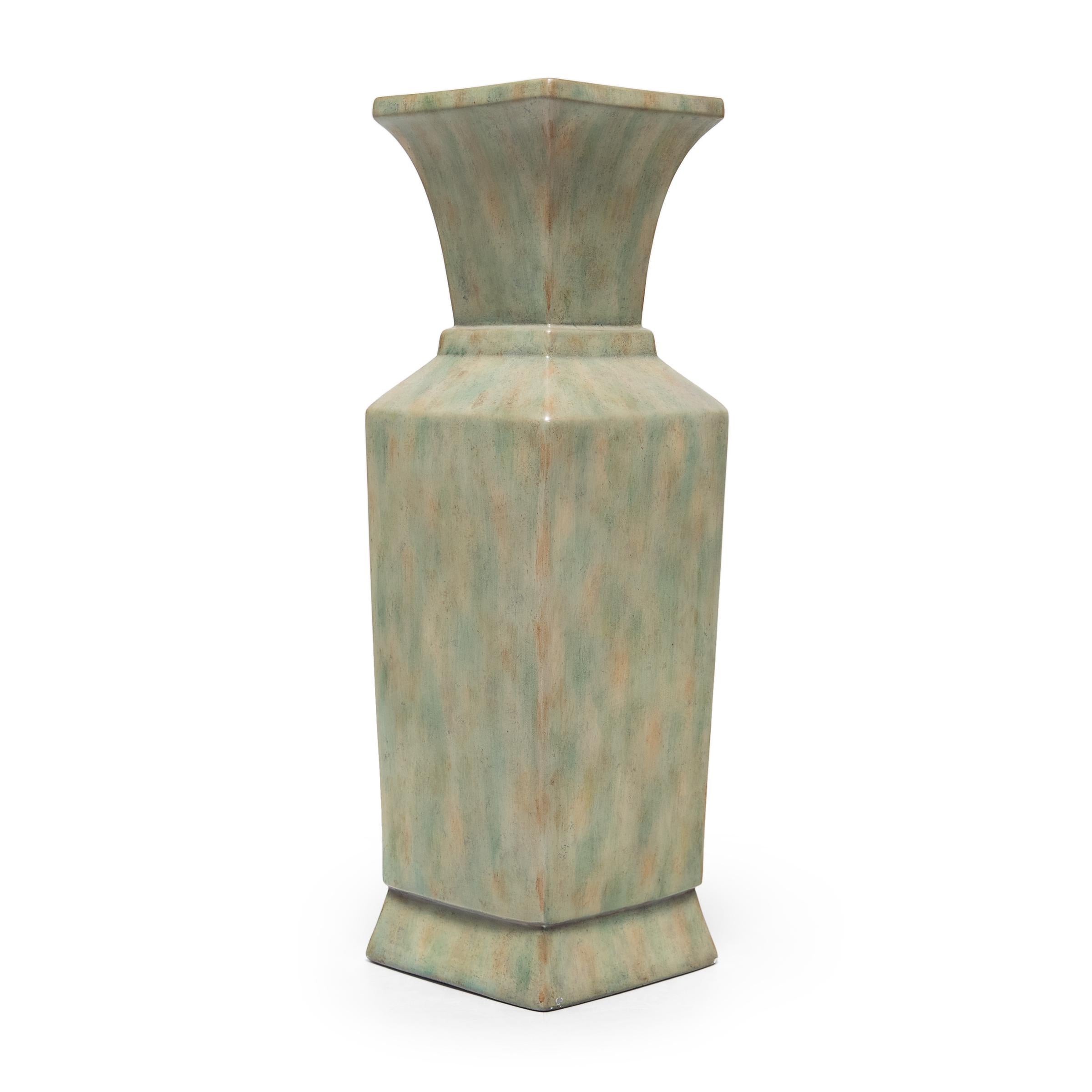A contemporary iteration of the classic Chinese phoenix-tail vase form, this tall porcelain urn by interior design house Maitland-Smith features a square body with angular shoulders and a flared top. A mottled glaze coats the exterior in a palette
