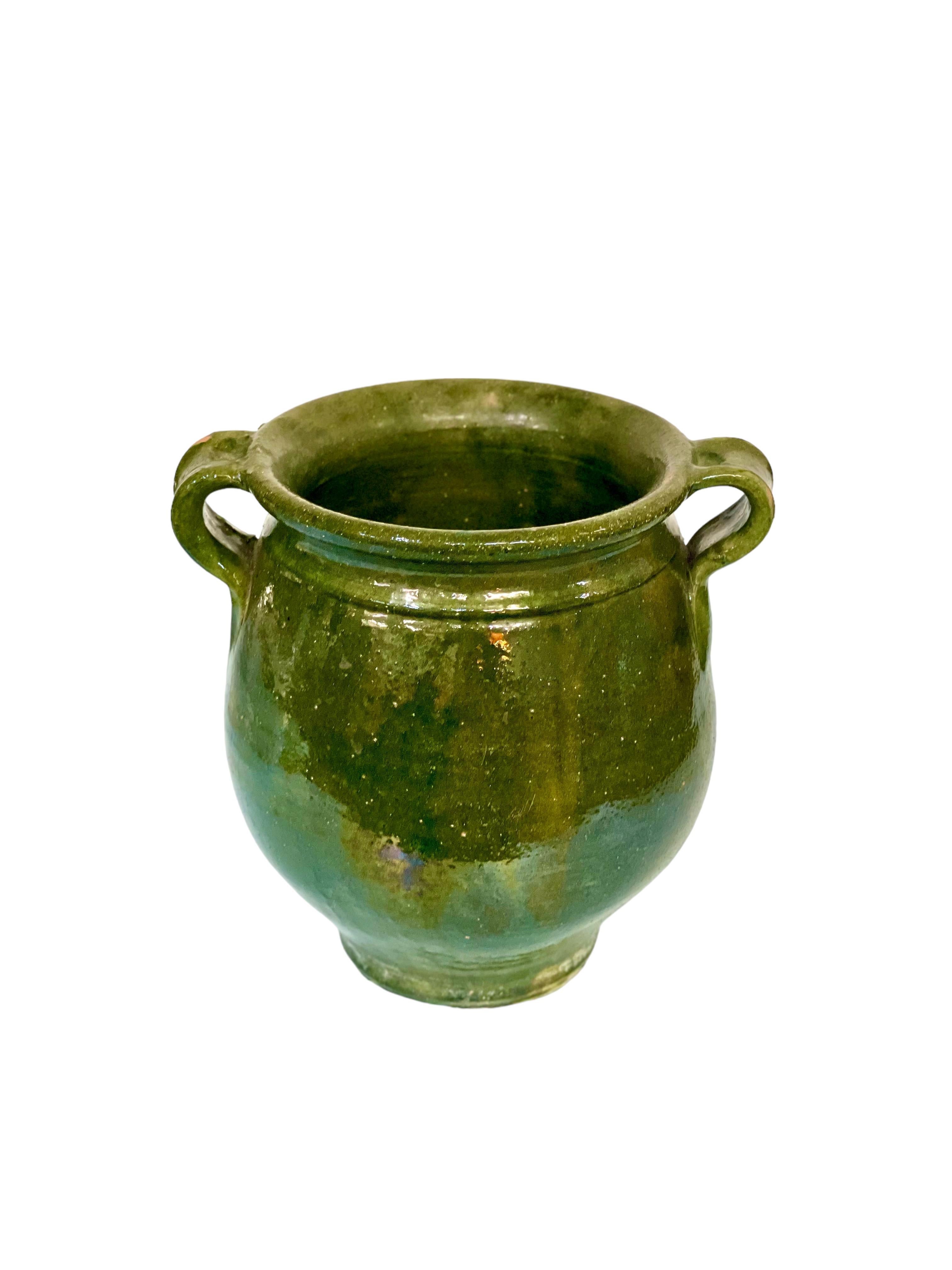 Traditional French terracotta confit pot with dark green glaze and two side handles. Dating from the 19th century, this vessel was used to conserve food – mainly meats in fat – before the invention of refrigeration.