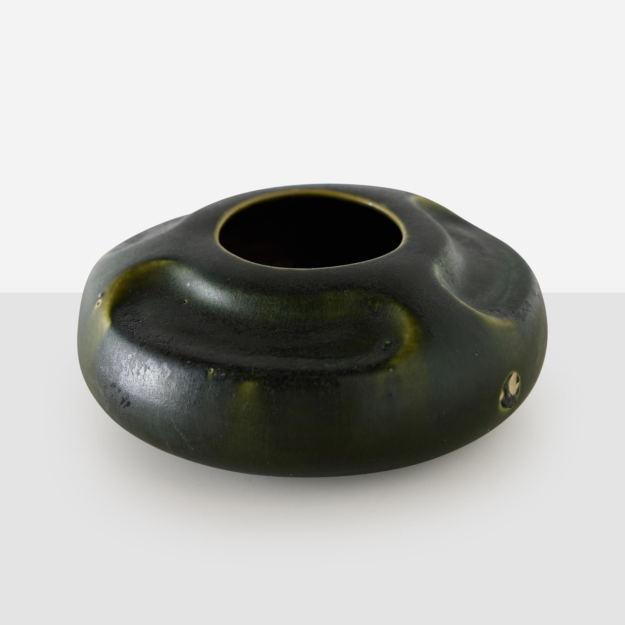 Vaso smaltato verde della ceramica di Arequipa

Vaso in gres di Arequipa Pottery, prodotto in California nel 1912. La forma bassa e arrotondata presenta un bordo ondulato e uno smalto verde opaco con variazioni naturali. Sulla base è riportato il