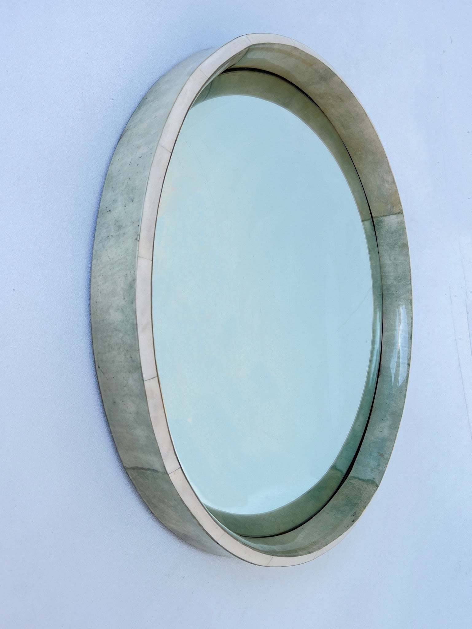 Glamorous 1980’s Italian lite green stain goatskin parchment paper and white bone lacquered frame convex mirror by Aldo Tura.
In beautiful vintage condition.
Measurements: 26.5” Diameter 2.75” Deep. 