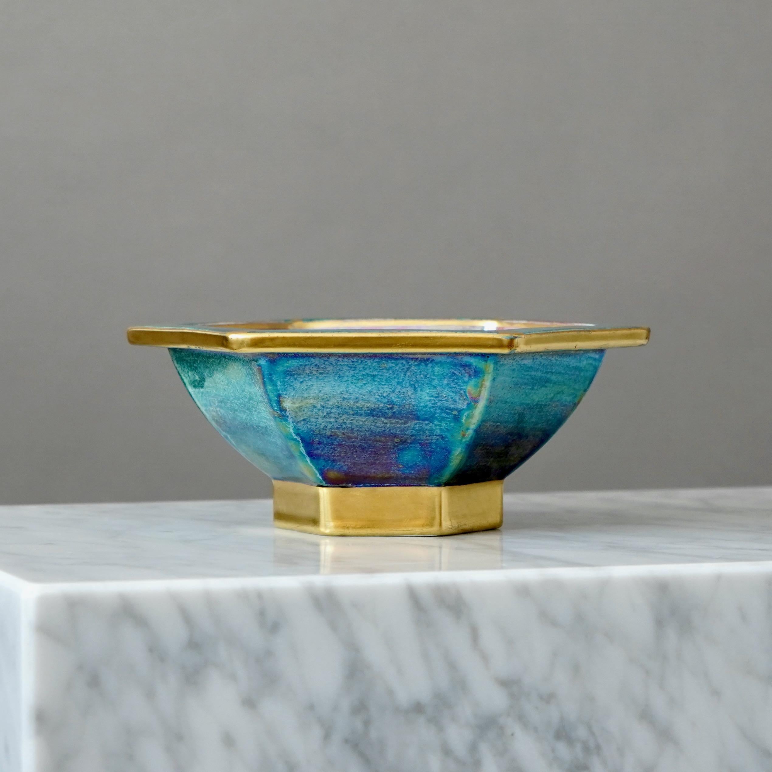 Un cuenco precioso con un sorprendente esmalte brillante y detalles dorados pintados a mano. Gracia escandinava / Art Decó.
Fabricado por Josef Ekberg en Gustavsberg, Suecia, años 1920.

Gran condición. 
Con la marca del fabricante.

JOSEF EKBERG
