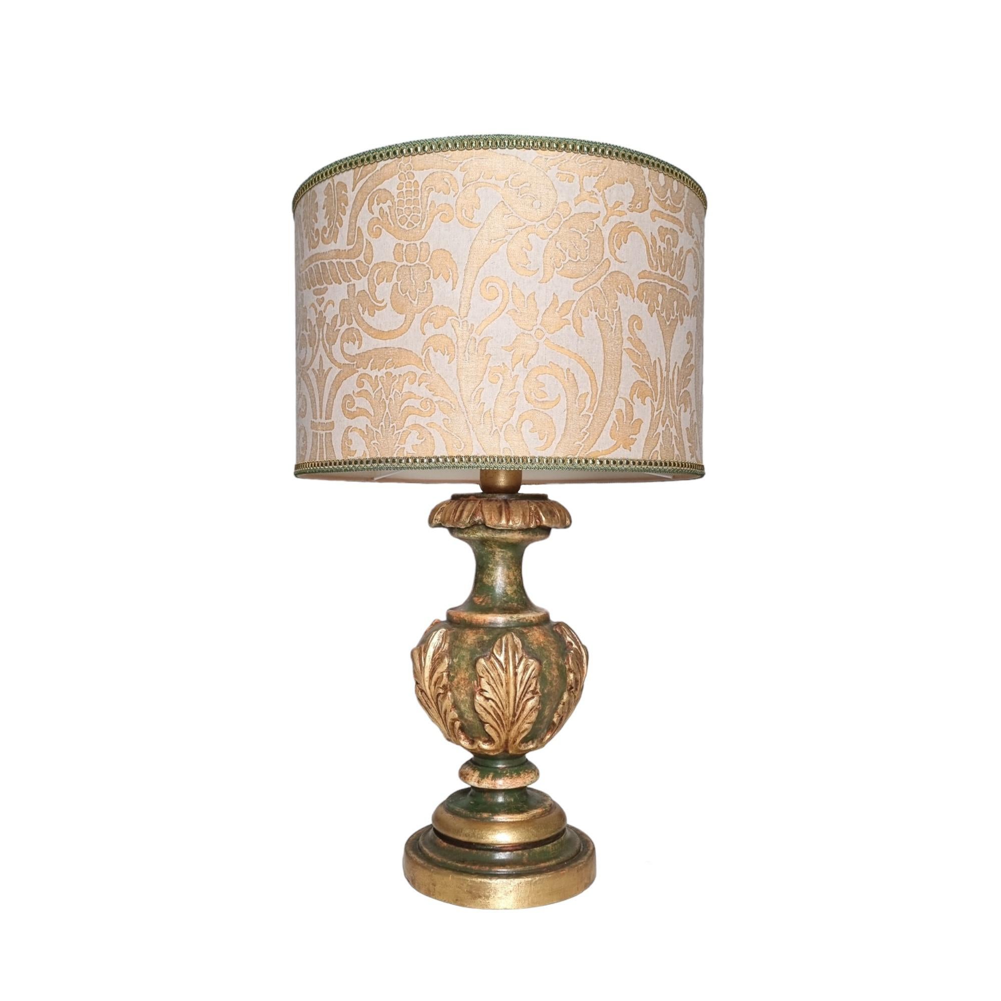 This is an absolutely fabulous green and gold leaf lacquered turned wood table lamp on a round base, handcrafted in Tuscany (Italy) and finished with antique patina. Carved acanthus leaf accents with gold leaf finish.

The drum round lampshade is