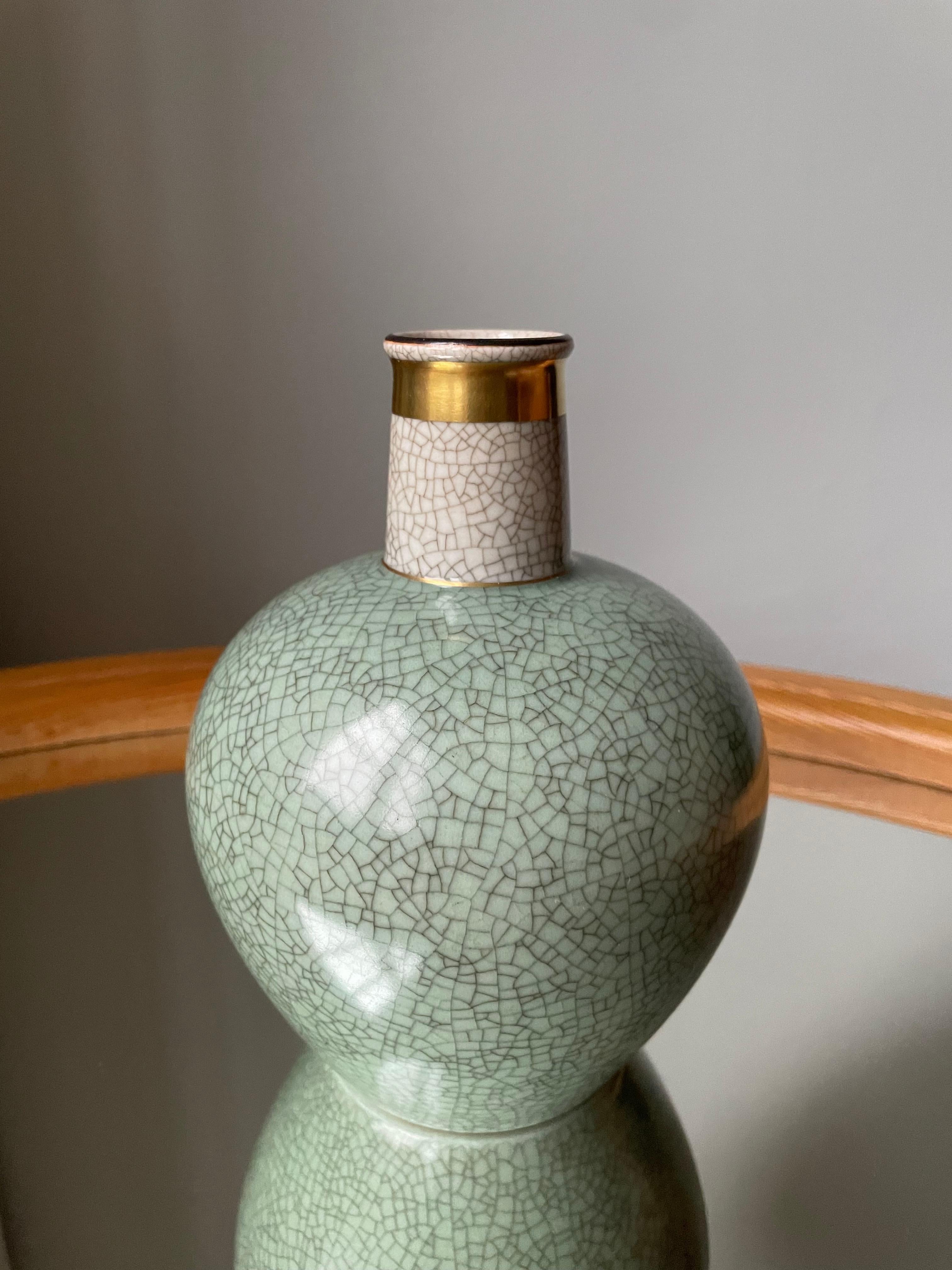 Vintage Royal Copenhagen porcelain vase with green and cream colored crackle glaze and simple decorative golden bands around top and base. Signed and stanped under base.
Beautiful, seemingly unused vintage condition. 
Denmark, 1950s.