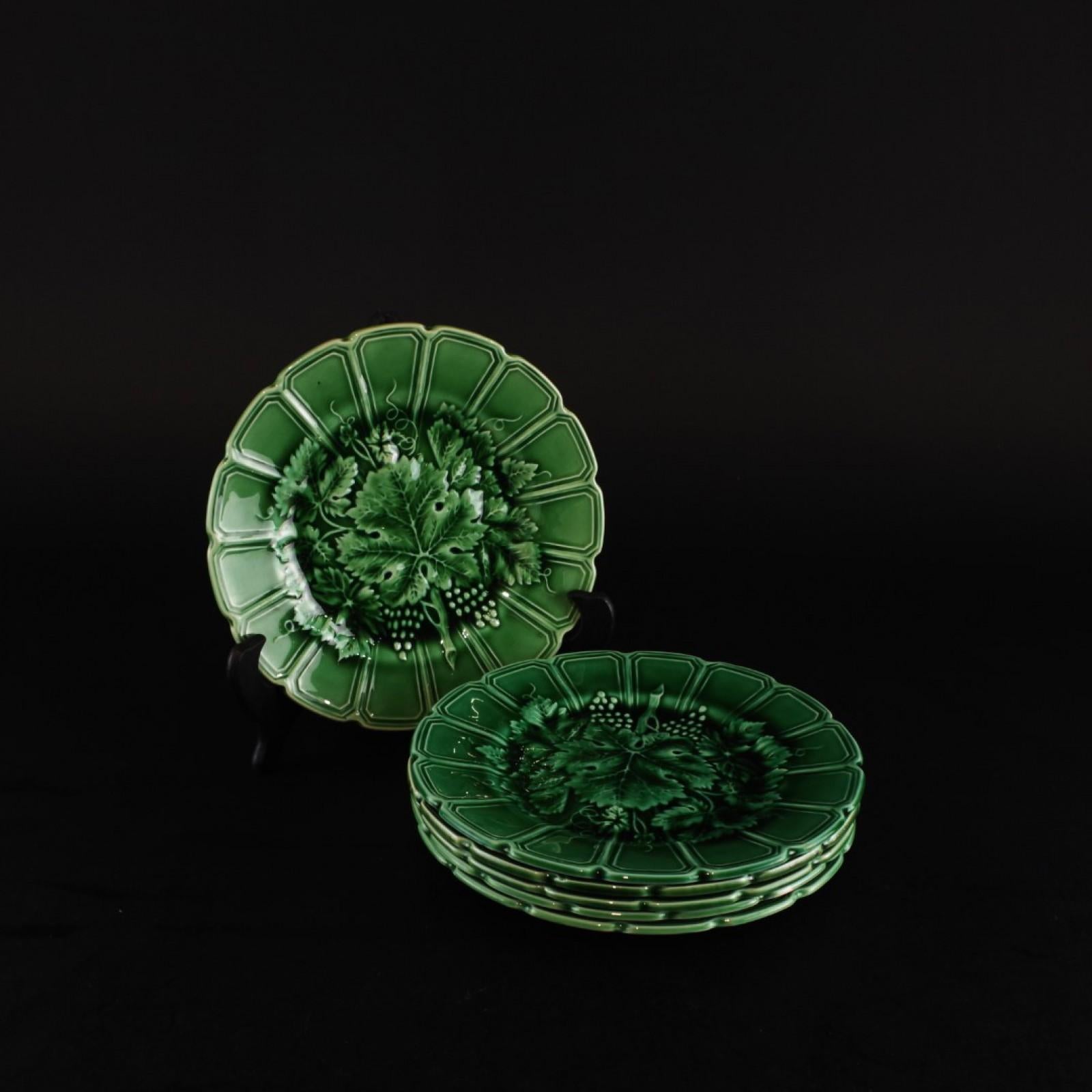This splendid set of six late 19th to early 20th-century french majolica plates comes from Sarreguemines, France. Each plate features beautifully scalloped rims and intricate designs of vine leaves and grape clusters in the center, all in a striking