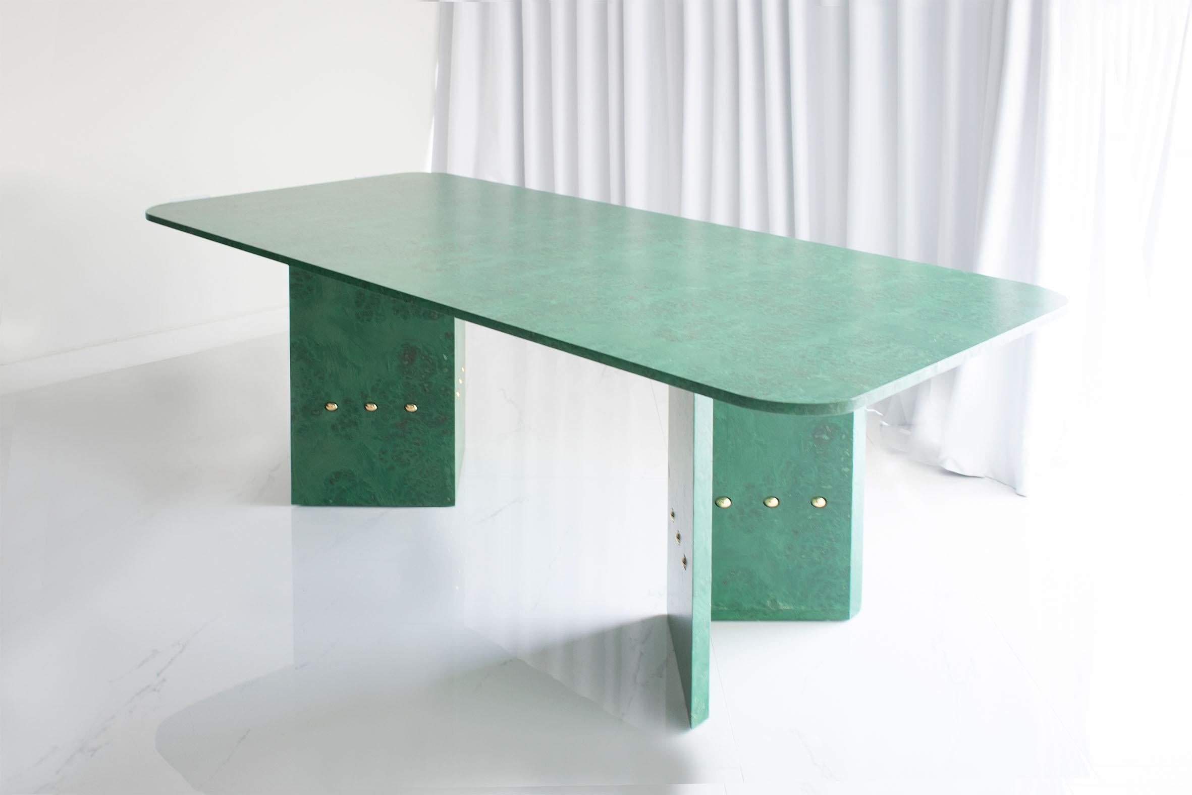 Green high table by Studio Christinekalia
Dimensions: W 110 x D 210 x H 75 cm.
Materials: Wood, mappa burl veneer, solid brass. 

This dining piece is a bold chromatic statement conceived with fine detailing. Its timeless design brings a piece