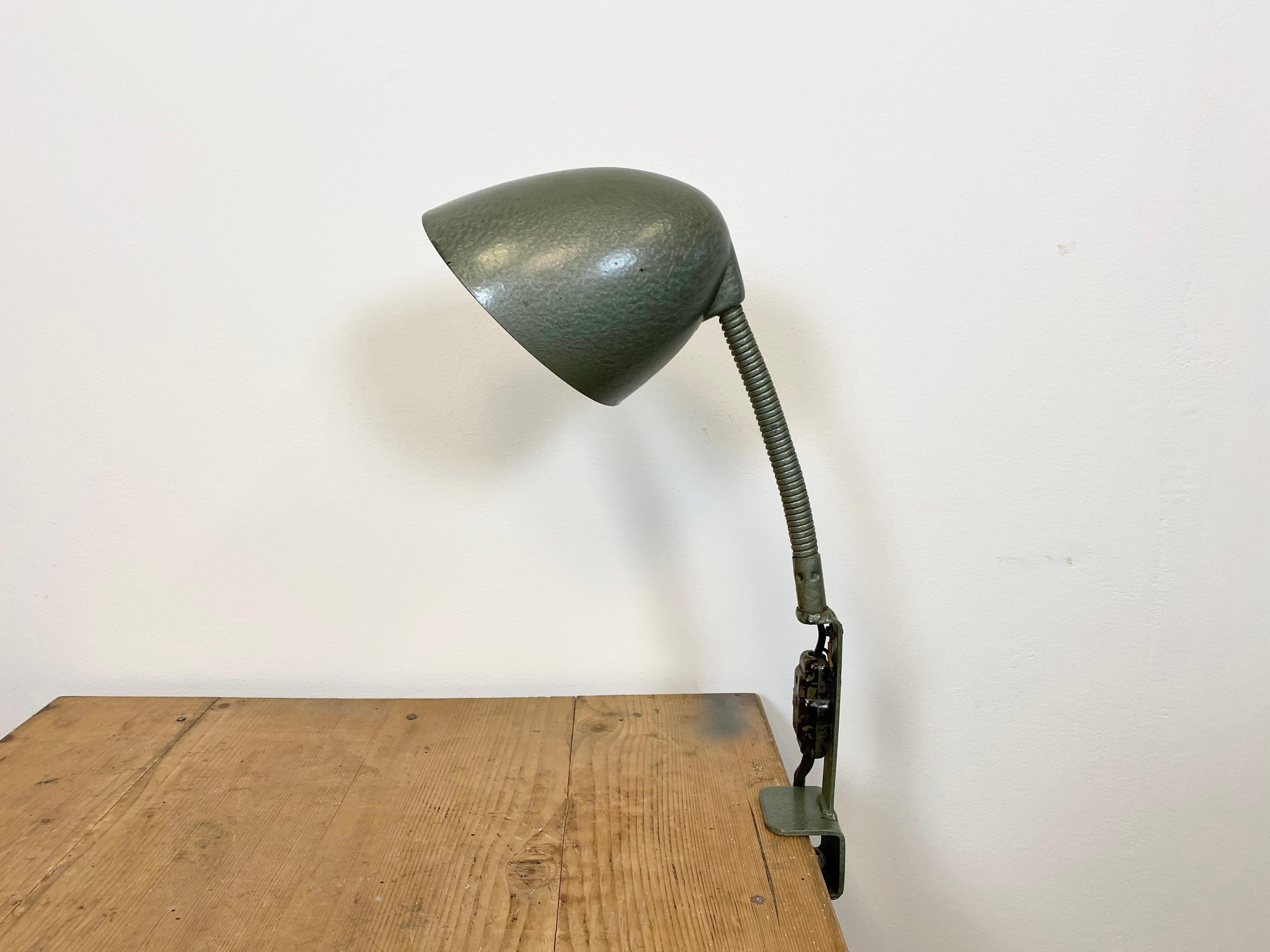 Green hammer paint industrial table lamp made by Elektroinstala Decín in former Czechoslovakia during the 1960s. It features a bakelite shade and iron gooseneck and clamp base. The original socket requires E 27 light bulbs. Original switch. New