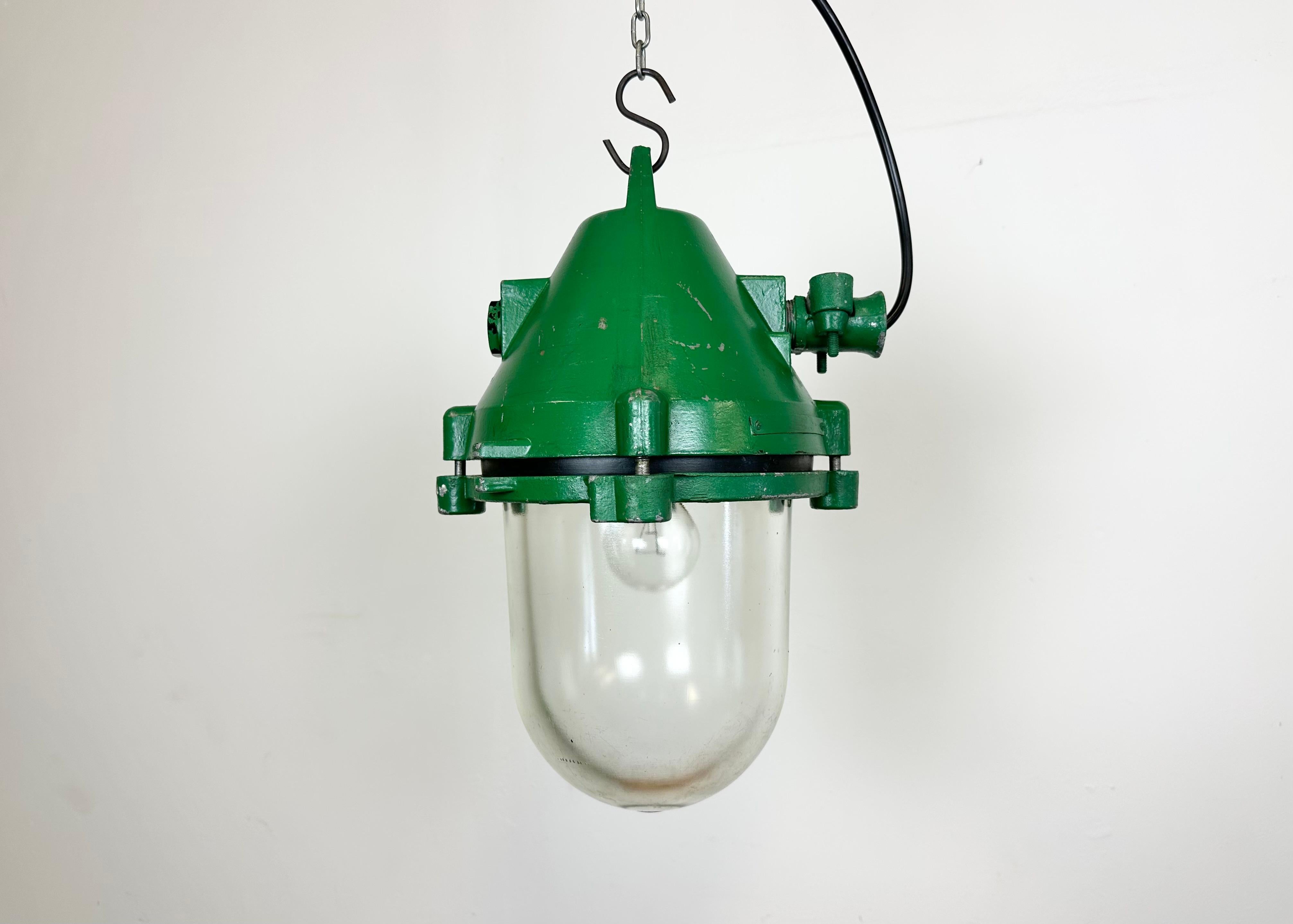 Green industrial explosion proof light with massive protective glass bulb. Made in former Czechoslovakia by Elektrosvit during the 1970s. It features a cast aluminium body and a clear glass cover. The original porcelain socket requires standard E27/