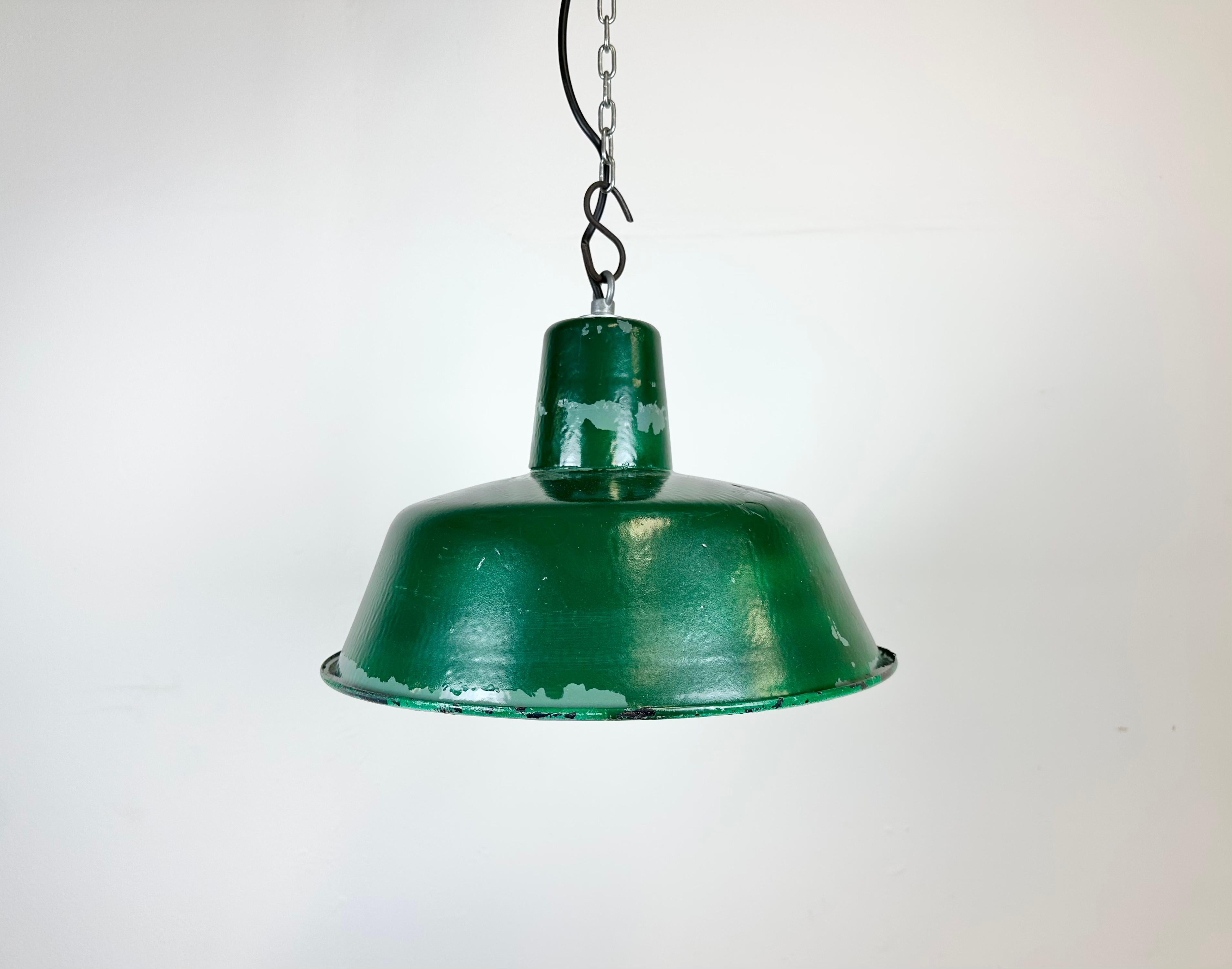 Industrial green pendant light made in Poland during the 1960s. White inside the shade. Iron top. The porcelain socket requires E 27/ E 26 light bulbs. New wire. Fully functional. The diameter of the lamp is 32 cm.The weight of the lamp is 1,2 kg.