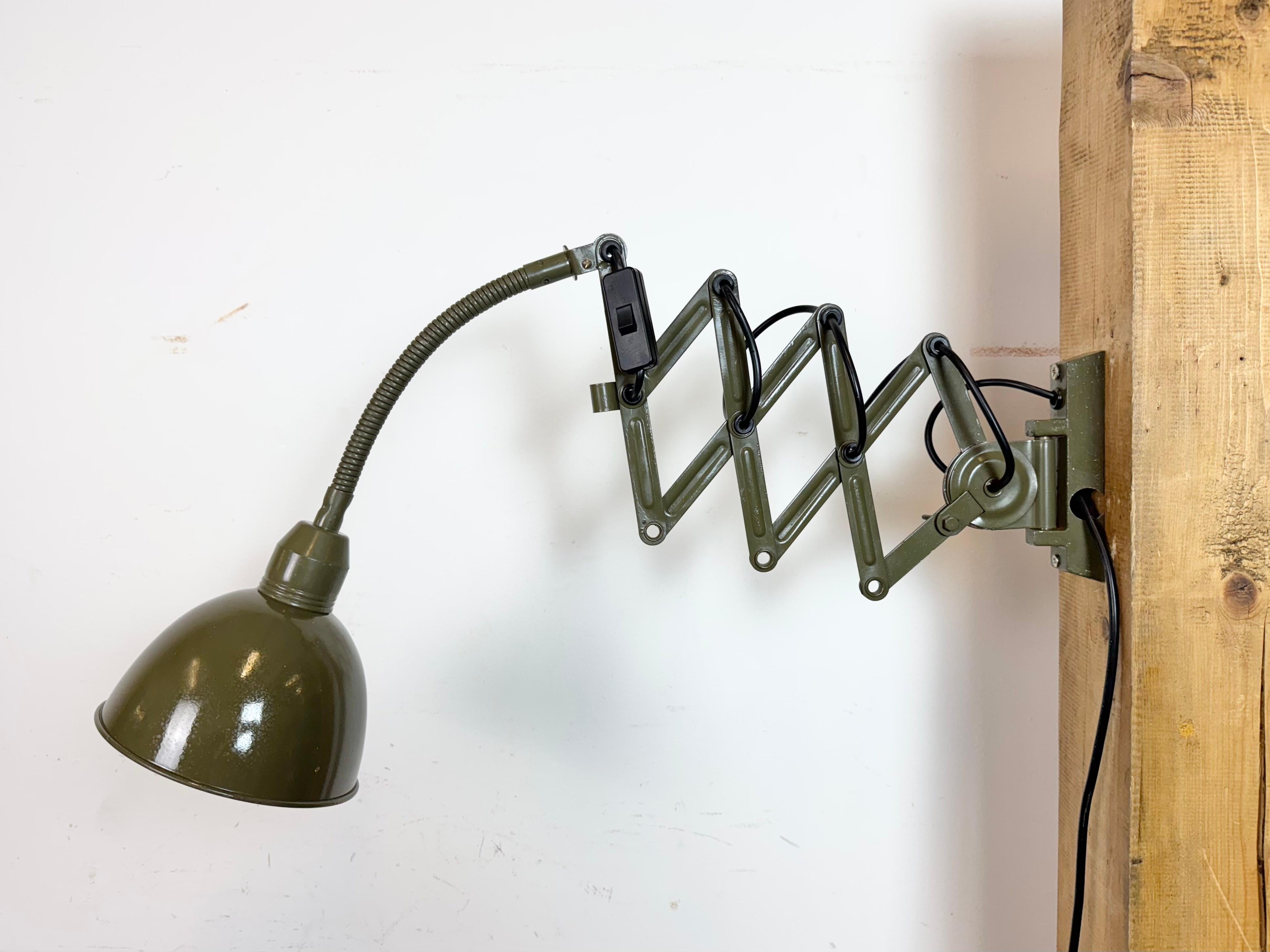 Este aplique industrial vintage de cuello de cisne regulable en color verde fue fabricado por Elektroinstala Dečín en la antigua Checoslovaquia durante la década de 1960. Tiene una pantalla metálica. El brazo de tijera de hierro es extensible y