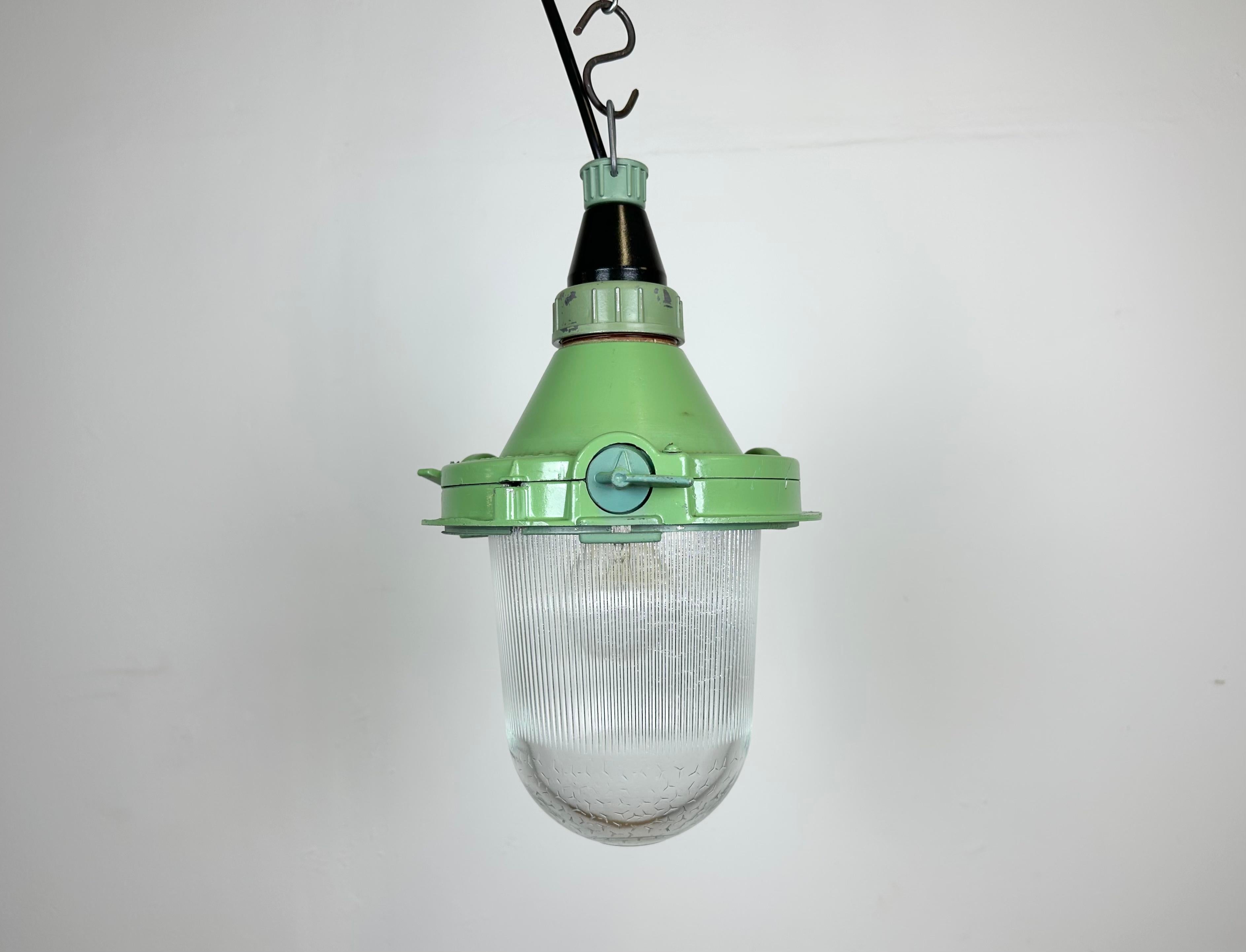 Green industrial light with massive protective glass bulb. Made in former Soviet Union during the 1960s. It features cast aluminium body with bakelite top and a glass cover. The socket requires standard E27 / E26 lightbulbs. Newly wired. Weight: 2.3