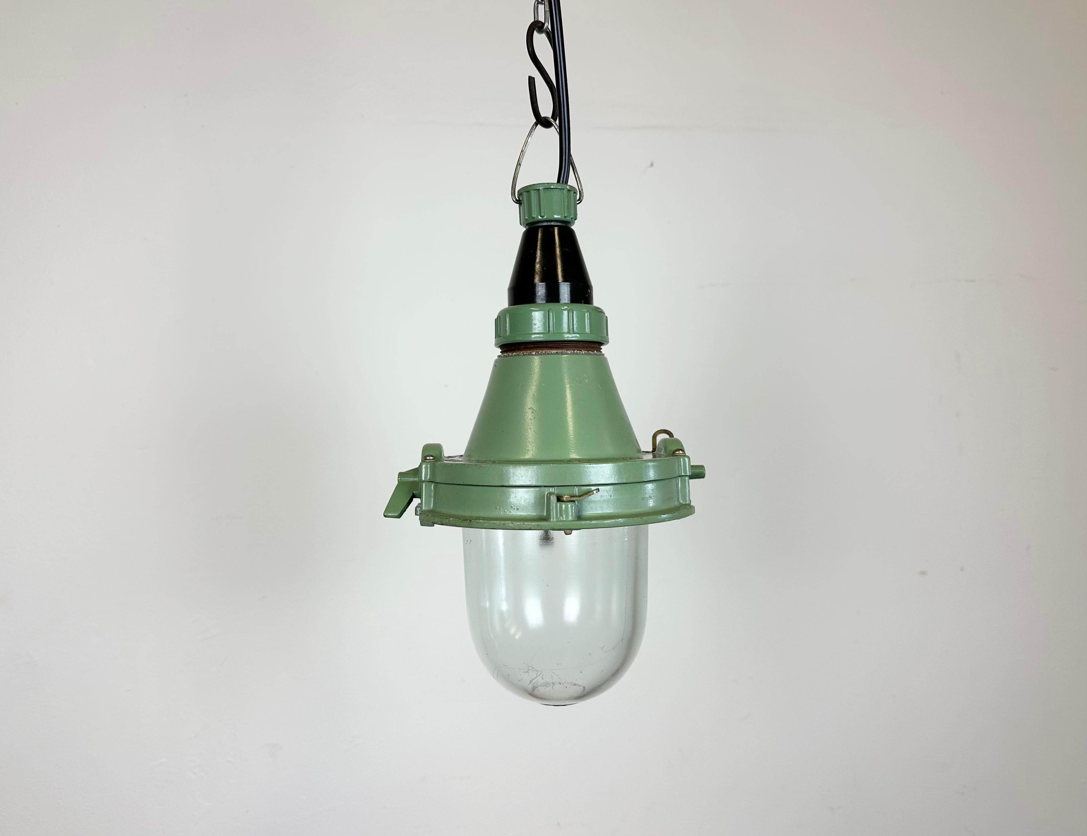Green industrial light with massive protective glass bulb. Made in former Soviet Union during the 1960s. It features a cast aluminium body with bakelite top and a clear glass cover. The socket requires standard E27 / E26 lightbulbs. Newly wired.