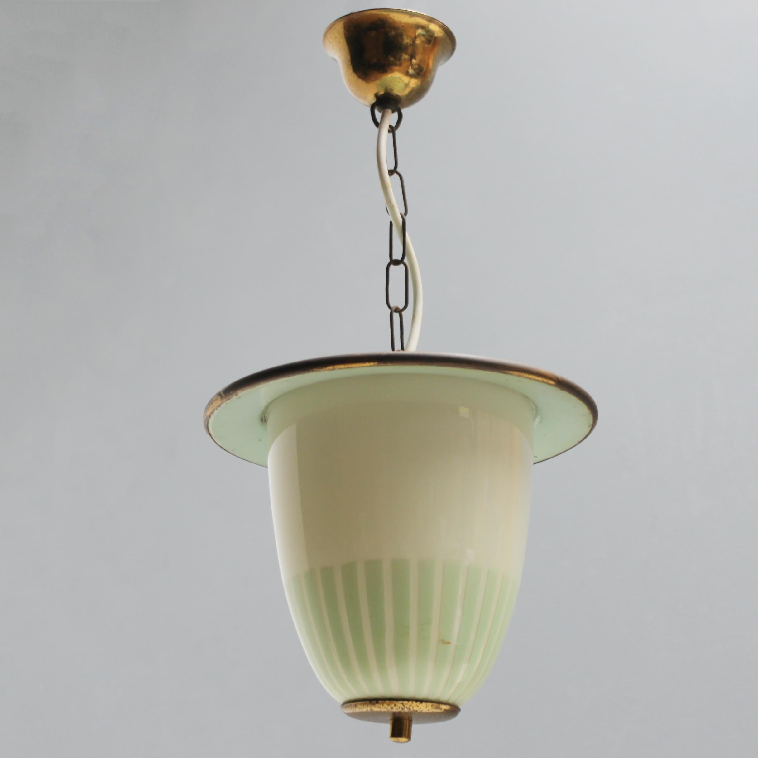 Elegant lantern on a chain in the style of Arredoluce. Brass with green lacquered metal and glass. Original canopy. 
One bulb: E27/E26 of max 60 watt, the electricity is used but in a good condition, approved to European standards. Good condition,