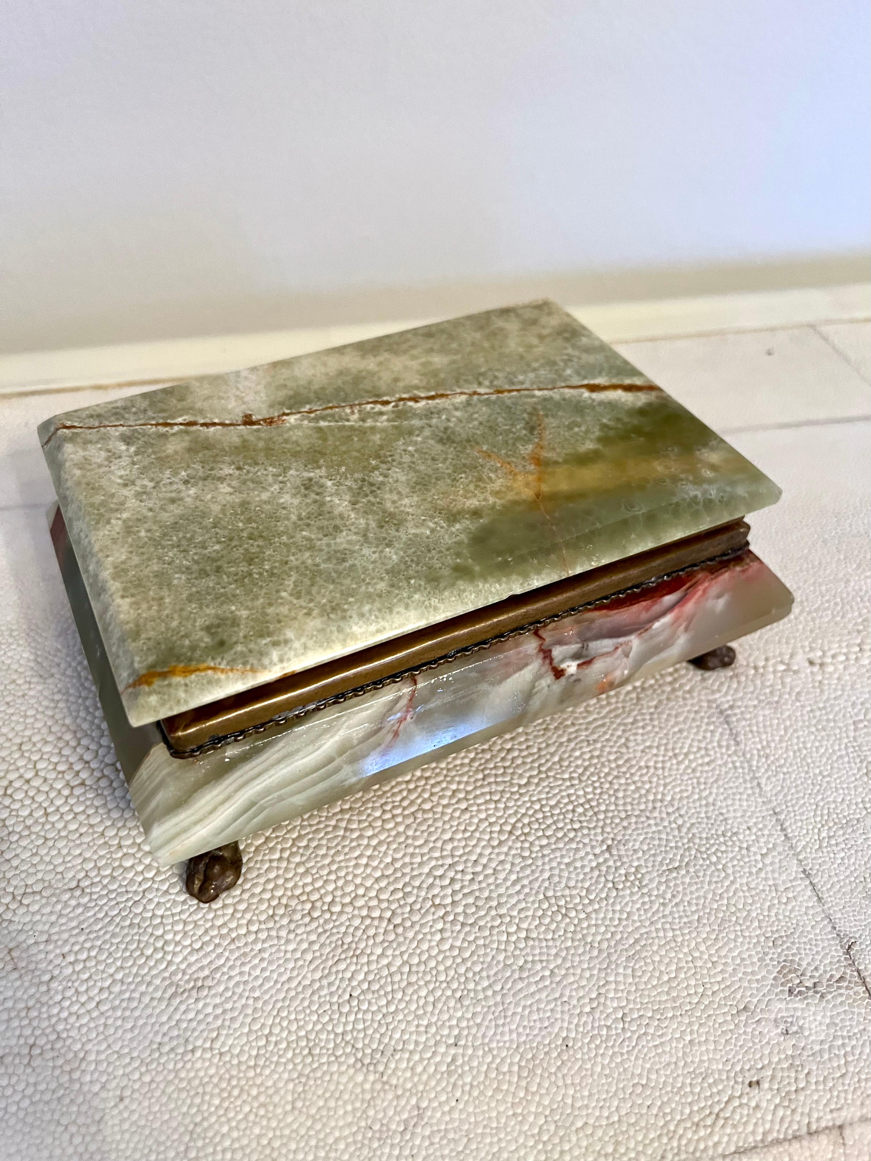 Italian green alabaster box with gorgeously patinated brass feet. The inside has a dark blue velveteen lining making it excellent for jewelry. A complement to any vanity or table, this piece opens and closes easily and stays securely shut thanks to