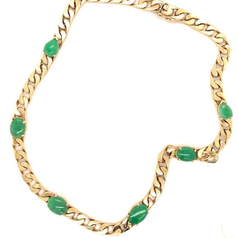One green jade 14K yellow gold curb link necklace featuring 6 prong set, oval and pear cabochon green jade stones measuring 15.4 inches long. Circa 1970s.

Striking, vibrant, eye-catching.

Additional information:
Metal: 14K yellow gold
Gemstone: