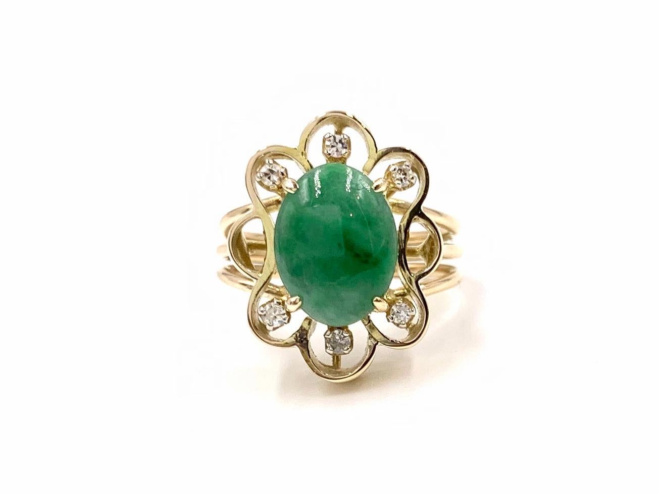 A 14k yellow gold hand made open flower design ring featuring an 11mm x 8.5mm oval genuine green jade and .06 carats of round diamonds. The green jade has an opaque transparency, smooth/reflective surface texture and exquisite natural veining