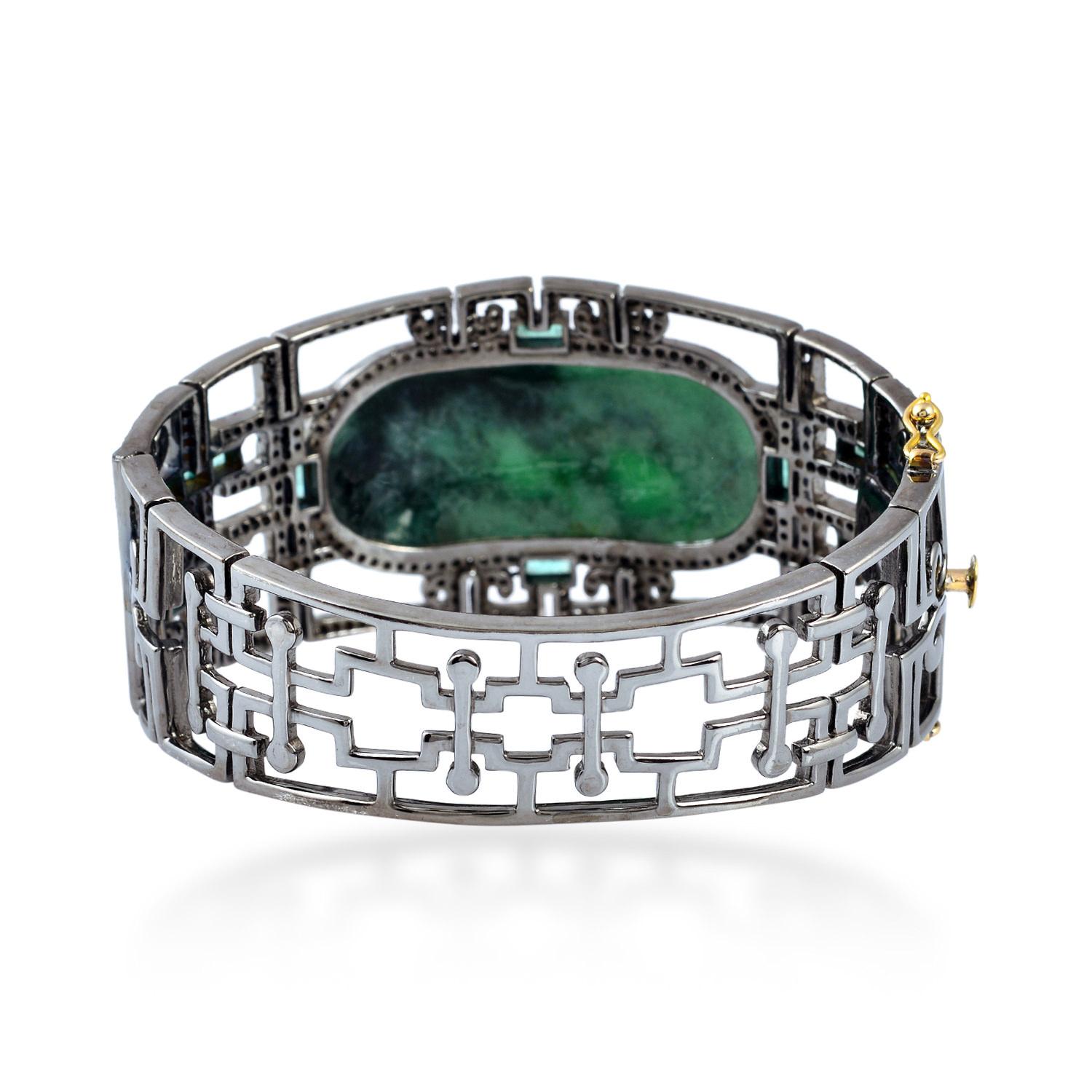 Oval oriental designer bangle with hand craved jade in center with round diamonds and emerald baguettes around.

Closure: Tounge Clasp

18Kt: 2.9g
Diamond: 2.86Ct
Sl: 34.928g
EMERALD: 1.75Ct
JADE: 32.5Ct 