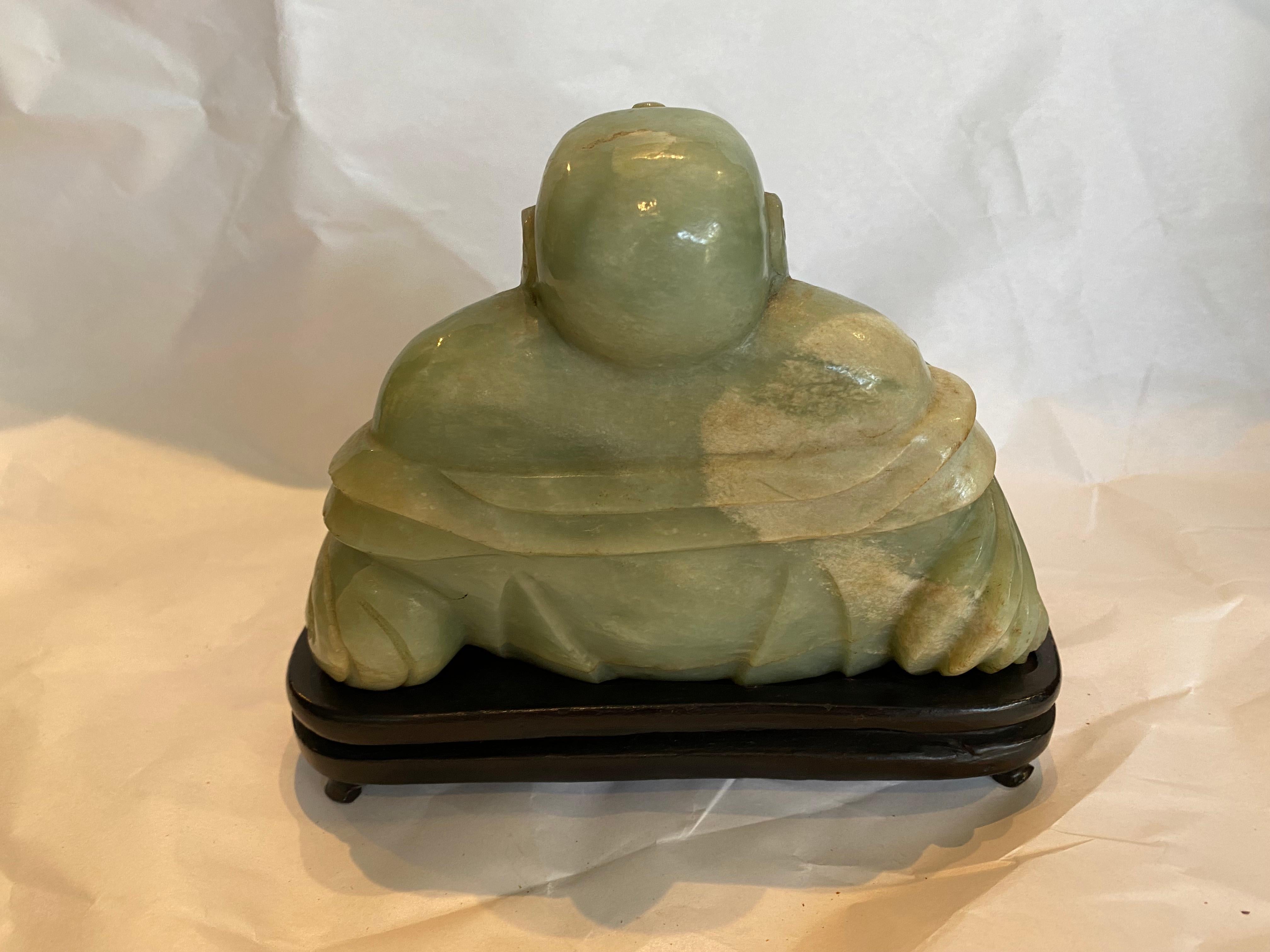 The god of happiness HO TOI is the happy buddha hand carved and sitting on a wood stand coming from a wealth estate.