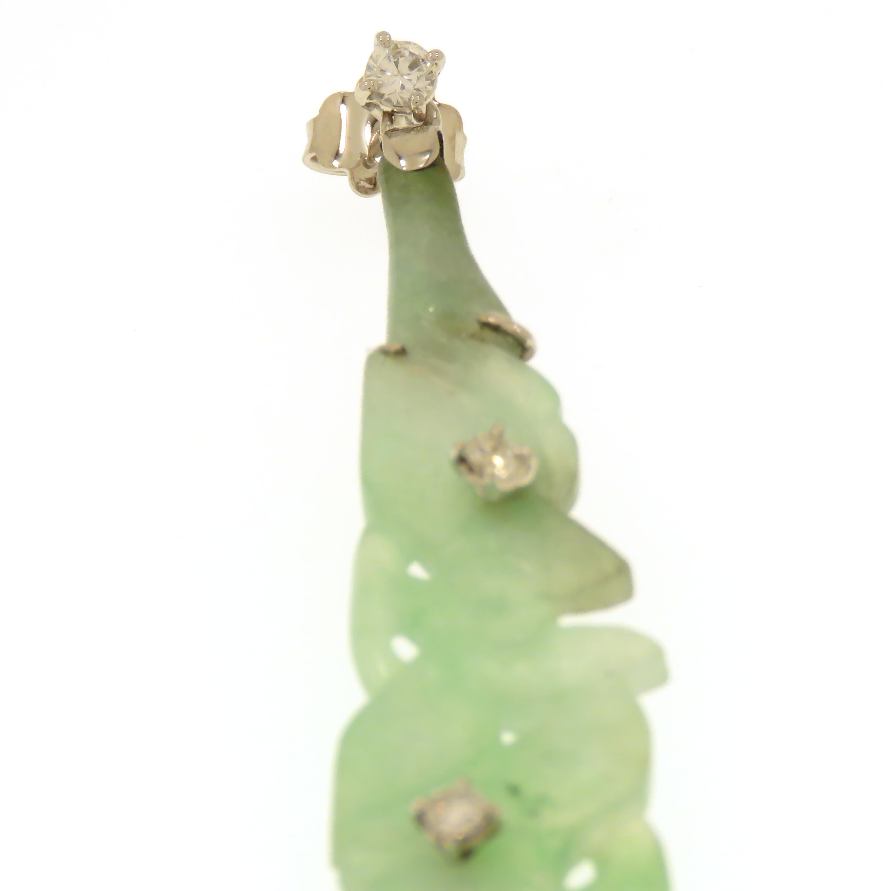 Lovely single long one sided earring featuring a beatiful engraved floral motif in natural green jade. Embellished by three brilliant cut diamonds 0.30 ctw and set in 18 karat white gold, handmade to fit the outline of the jade perfectly. The length