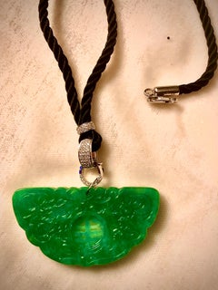 Green jade half circle shaped carved pendant with diamonds in silk cord