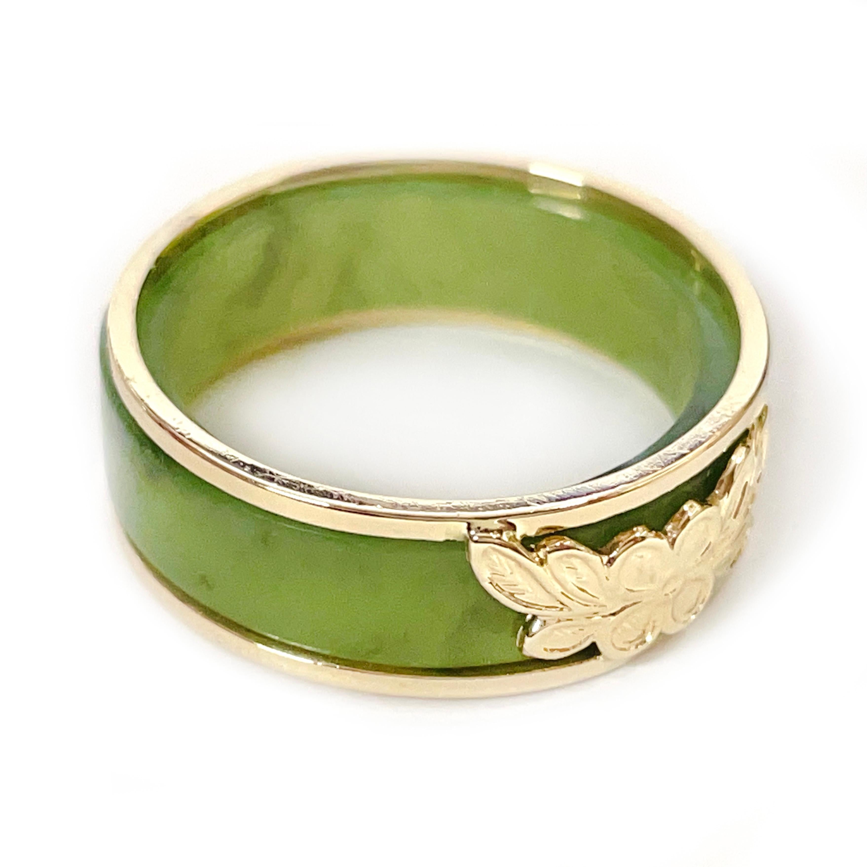 14 Karat Yellow Gold Green Jade Two-Part Ring. Two rings in one, a beautiful light sage green jade band and a yellow gold two band ring with a a four petal flower and leaves at the center. The ring measure 7mm wide and 2.4mm thick. The ring is size
