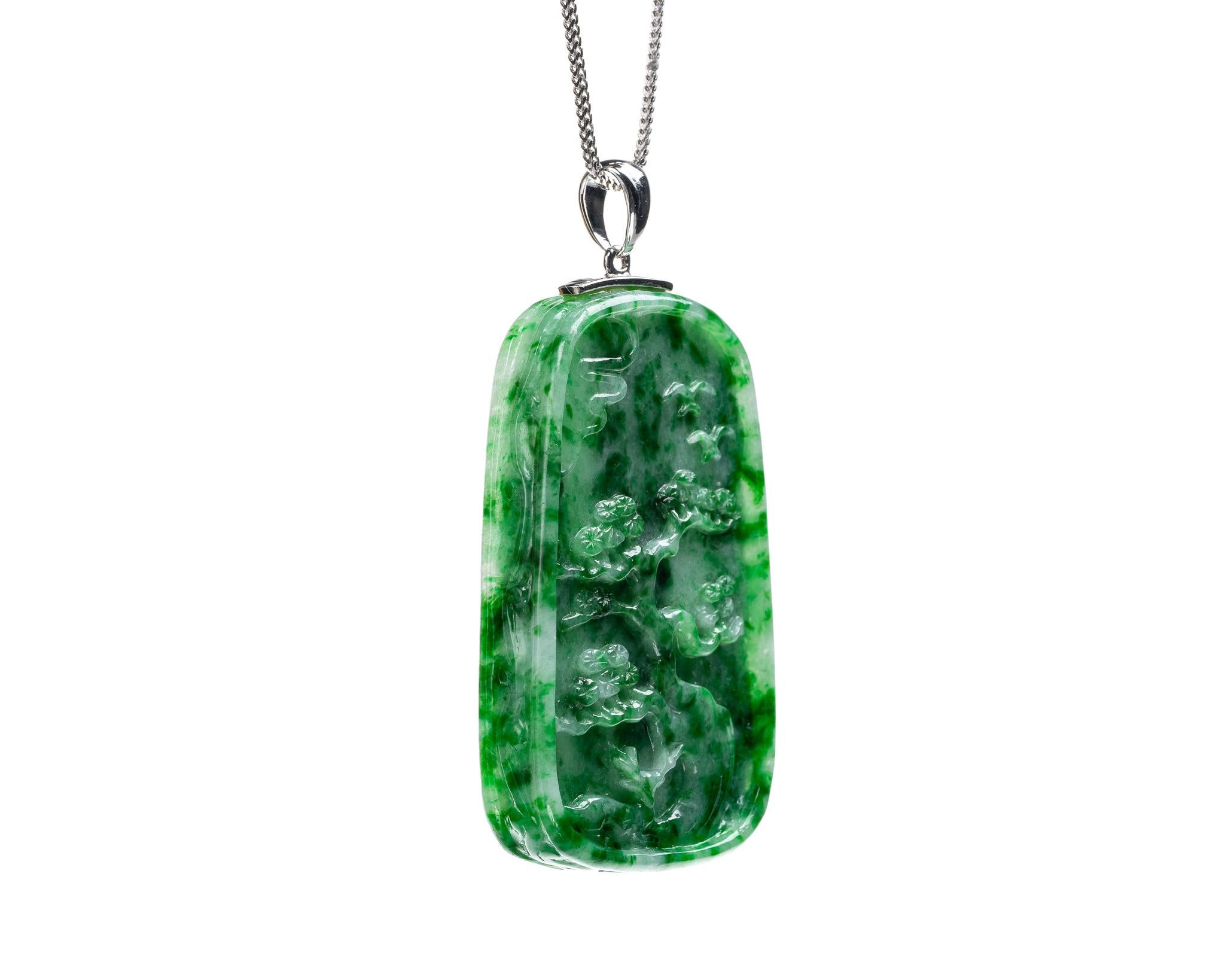 This is an all natural, untreated jadeite jade carved bamboo pendant set on an 18K white gold bail.  The carved bamboo symbolizes strength, growth and resilience.   

It measures 1.09 inches (27.8 mm) x 1.83 inches (46.5 mm) with thickness of 0.28