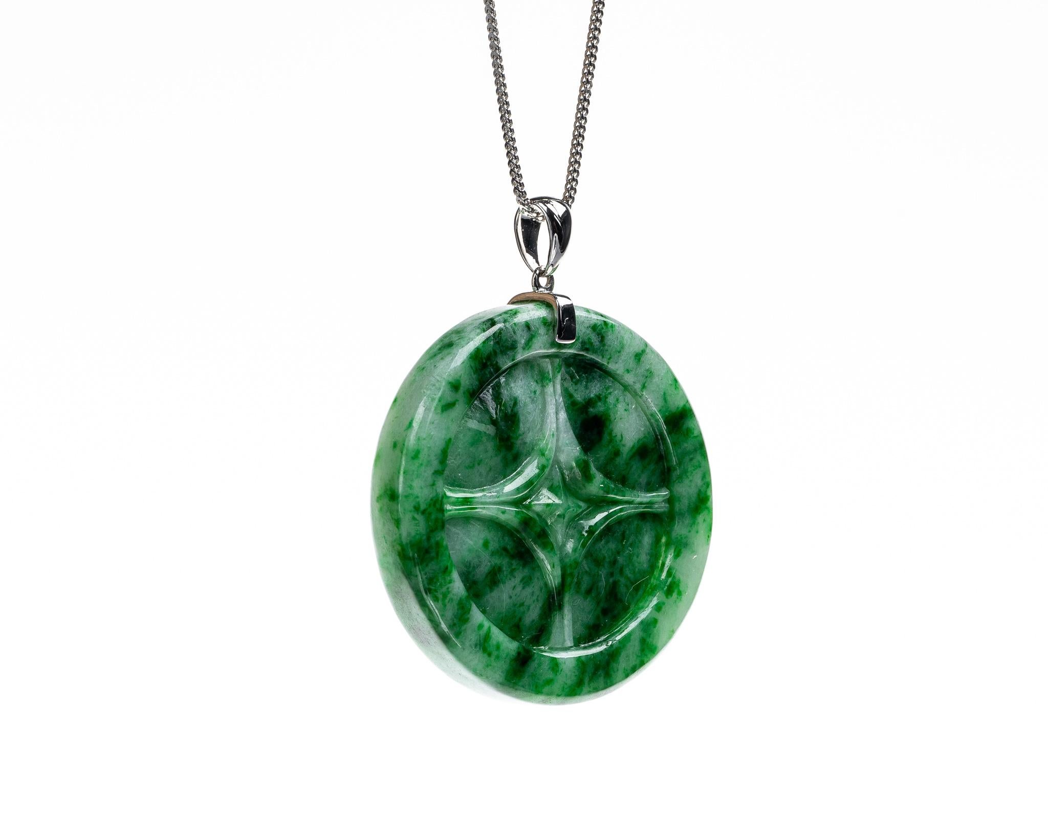This is an all natural, untreated jadeite jade carved coin pendant set on an 18K white gold bail.  The carved coin symbolizes money, wealth and prosperity.
   
It measures 1.49 inches (38mm) x 1.49 inches (38mm) with thickness of 0.25 inches (6.4mm)