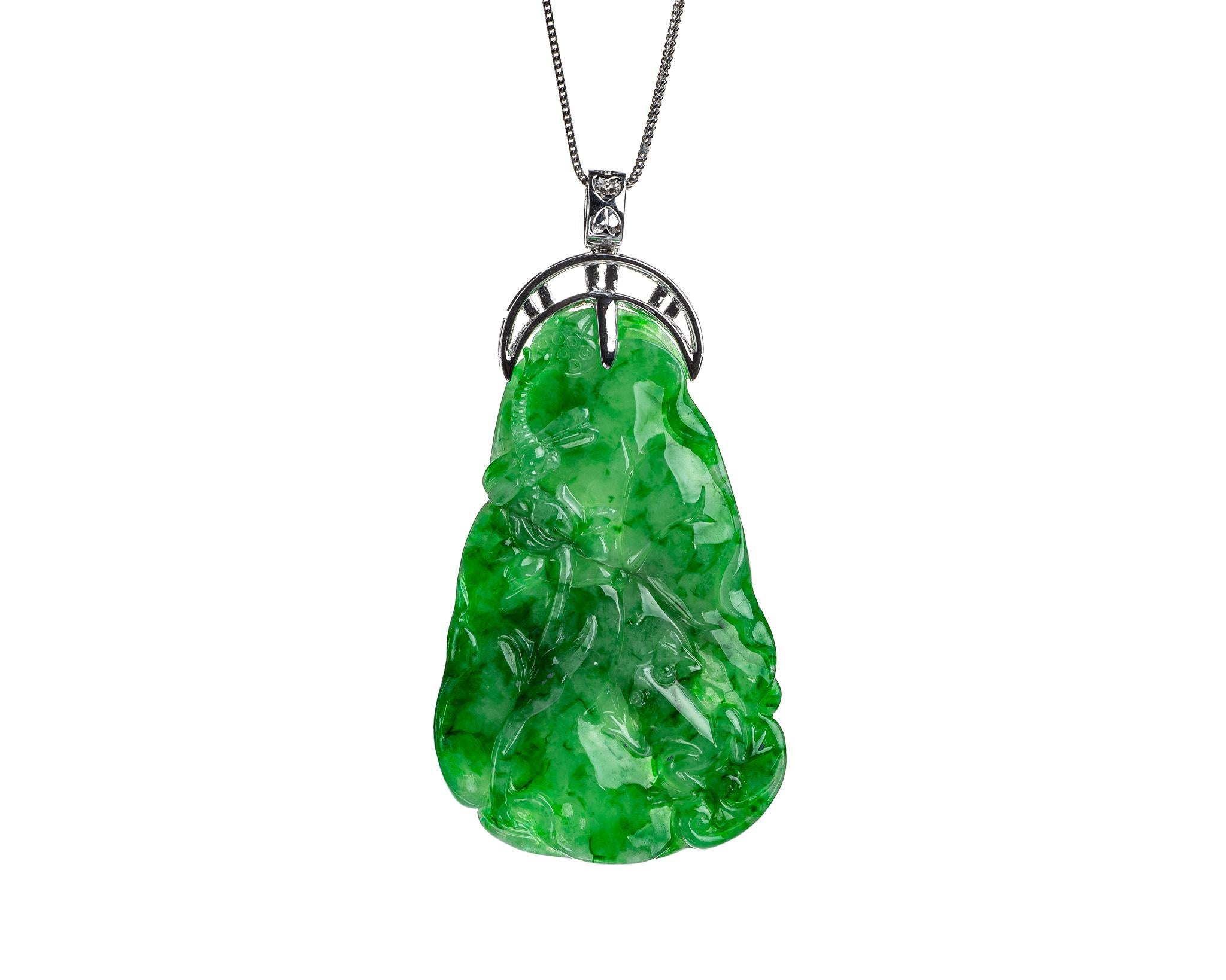 This is an all natural, untreated jadeite jade carved lotus leaf and dragonfly pendant set on an 18K white gold bail.  The carved lotus leaf symbolizes purity and enlightenment.   

It measures 1.52 inches (38.8mm) x 2.39 inches (60.7mm) with