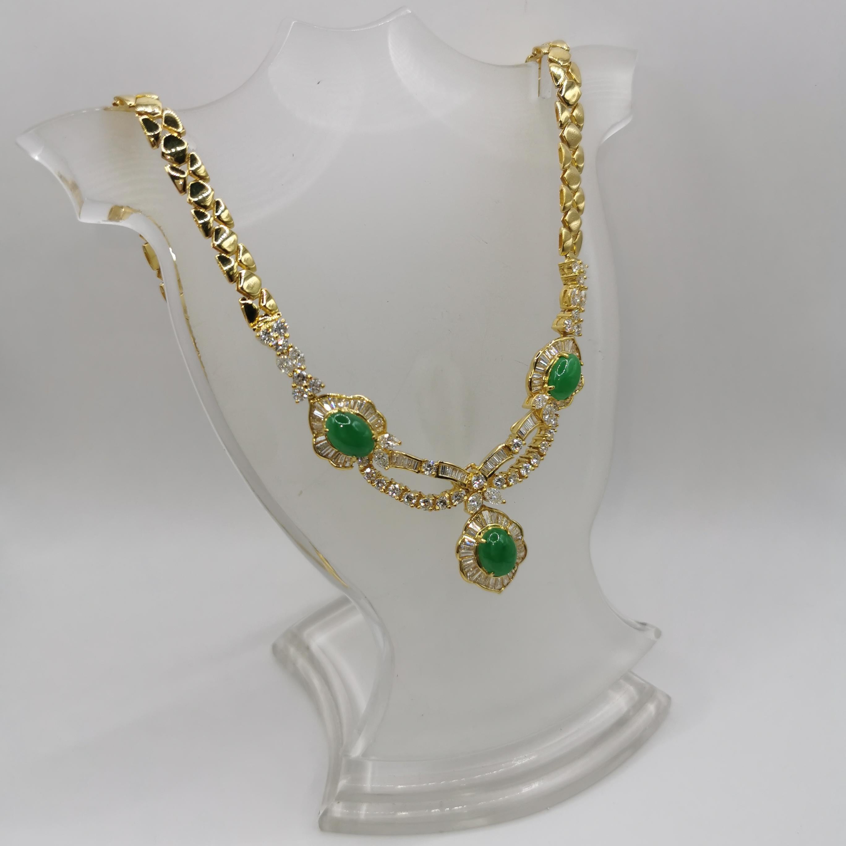 This one-of-a-kind extraordinarily unique vintage Green Jadite Diamond Yellow Gold Necklace is set with three beautiful translucent apple green cabochon jadeites at the center. Each jade is surrounded by paves of tapered baguette cut diamonds,