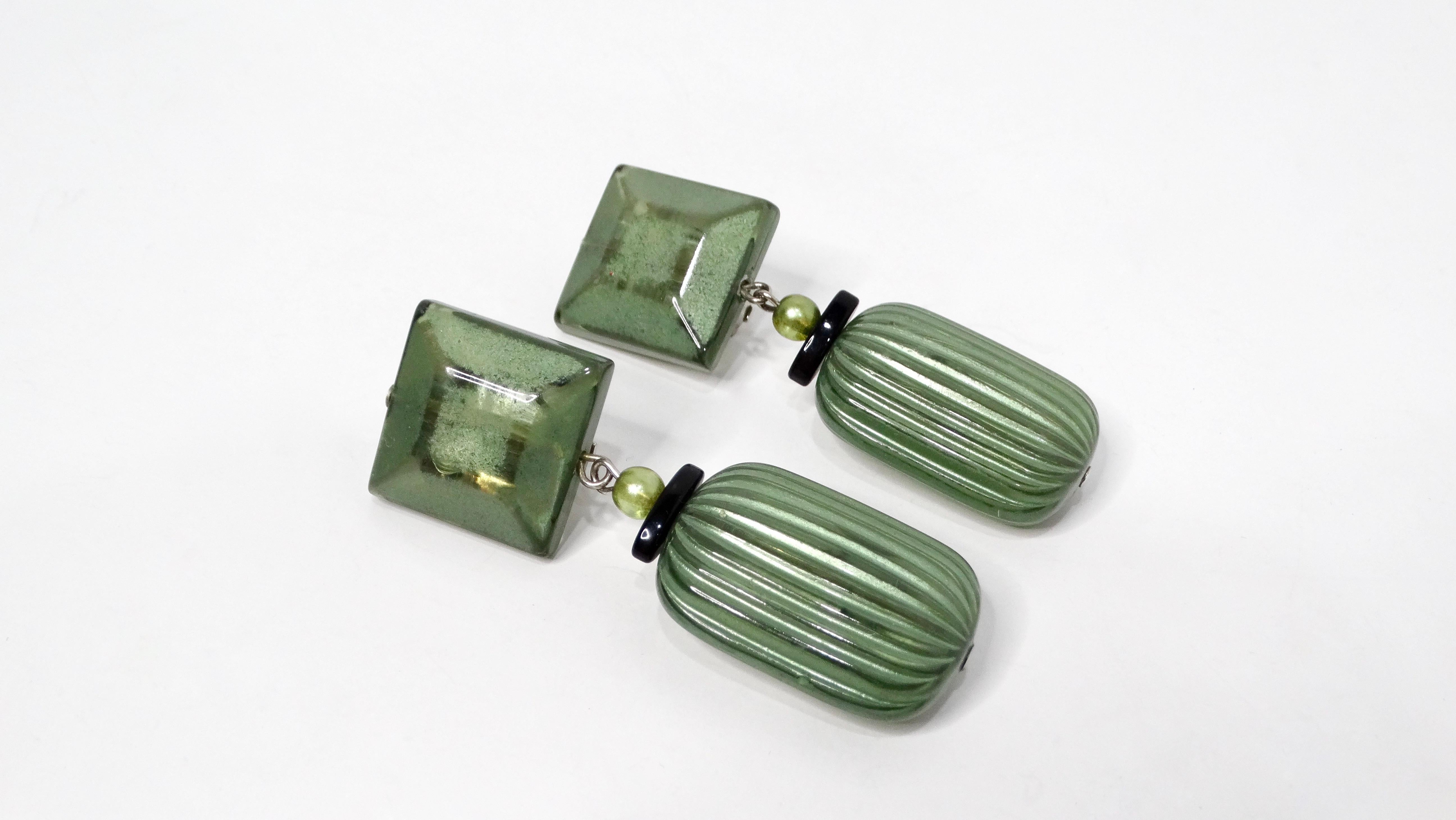 Die grünen Jewel-Tone Beaded Costume Clip-On Dangle Earrings sind eine fabelhafte Verschmelzung von kühnem Stil und lebendiger Eleganz. Diese auffälligen Ohrringe bestehen aus großen, leuchtend grünen Perlen, die das Aussehen von Edelsteinen