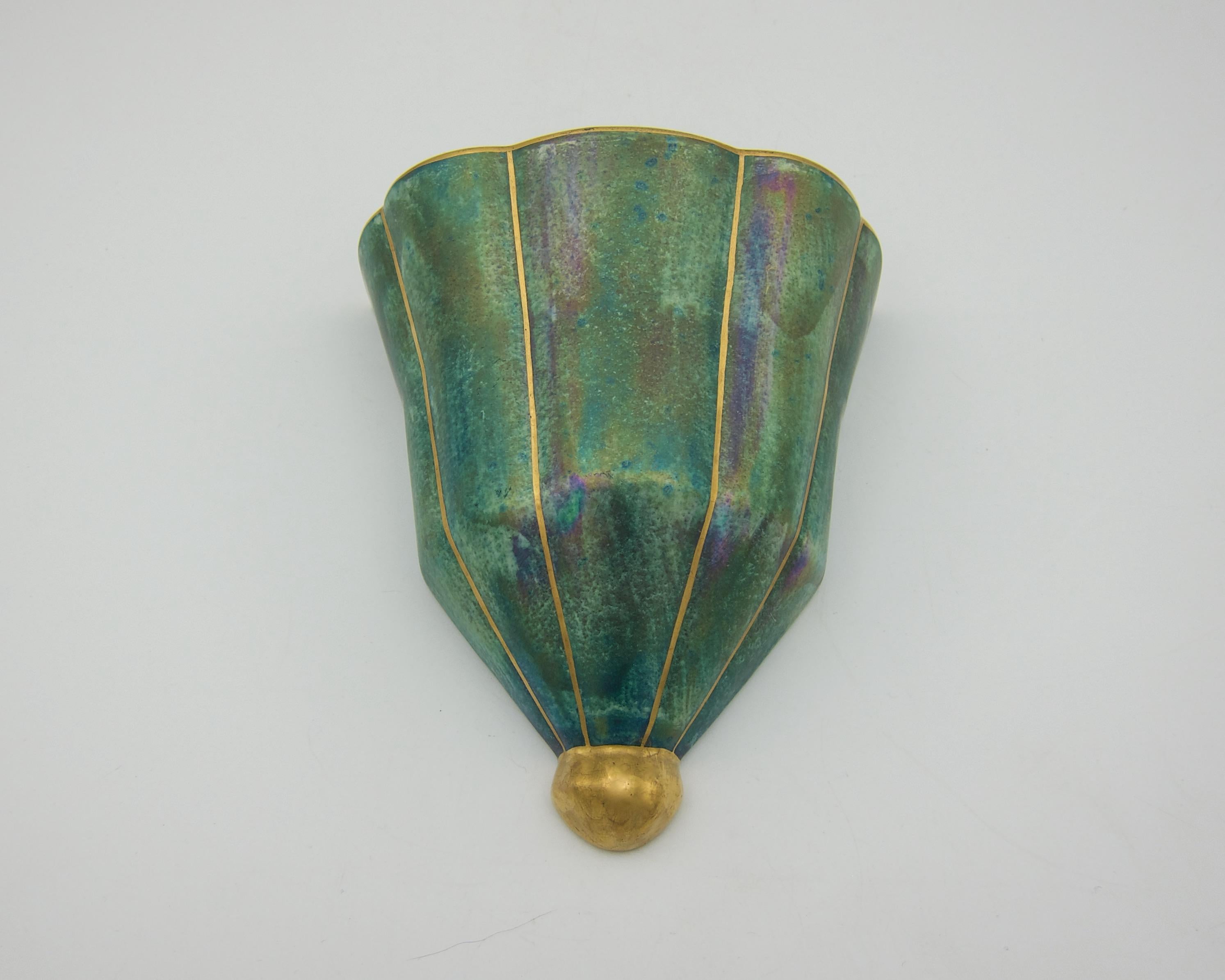 A Josef Ekberg (1877-1945) Art Deco wall pocket vase from the Gustavsberg Porcelain Factory of Sweden, produced during the second quarter of the 20th century. The lobed vessel fans outward and is decorated with a striking iridescent luster glaze of