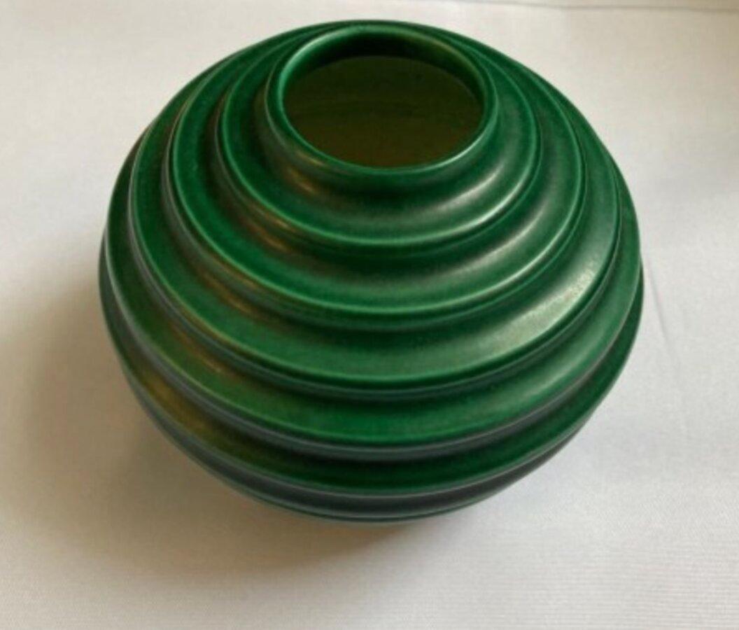 Let your fingers hold a world in your hands. See some small, sophisticated Swedish vases in globe form by Ewald Dahlskog. These earthly vessels transport the viewer elsewhere with each embossed stripe. 
. 
The Art Deco globose vases are bold, yet
