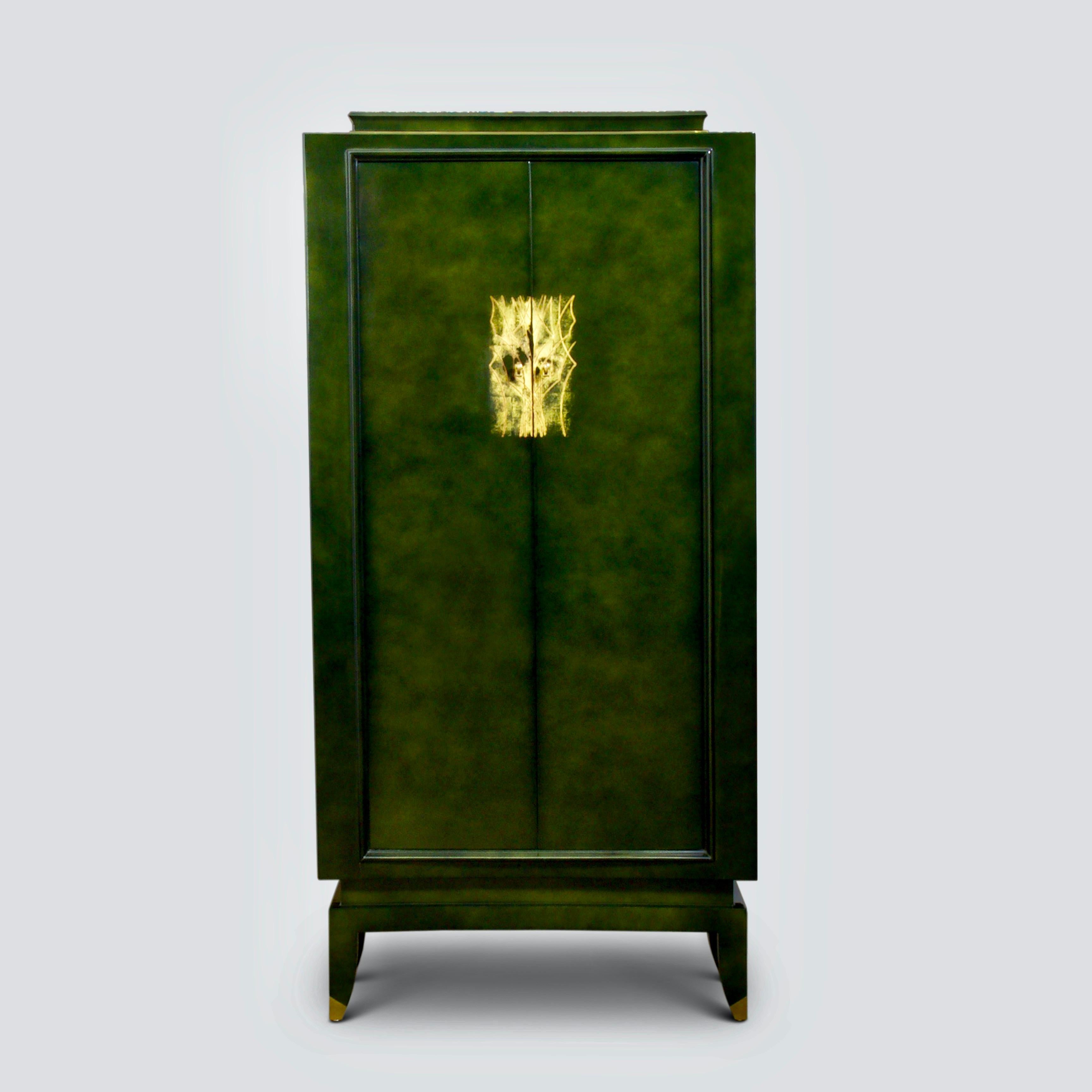 An important green lacquer and gilt cabinet by Andre Domin & Marcel Genevriere for Maison Dominique, circa
1945.

Lacquered to a deep green finish overlaid on a gold ground with applied gilt decorative pattern to the doors which lock using a pair