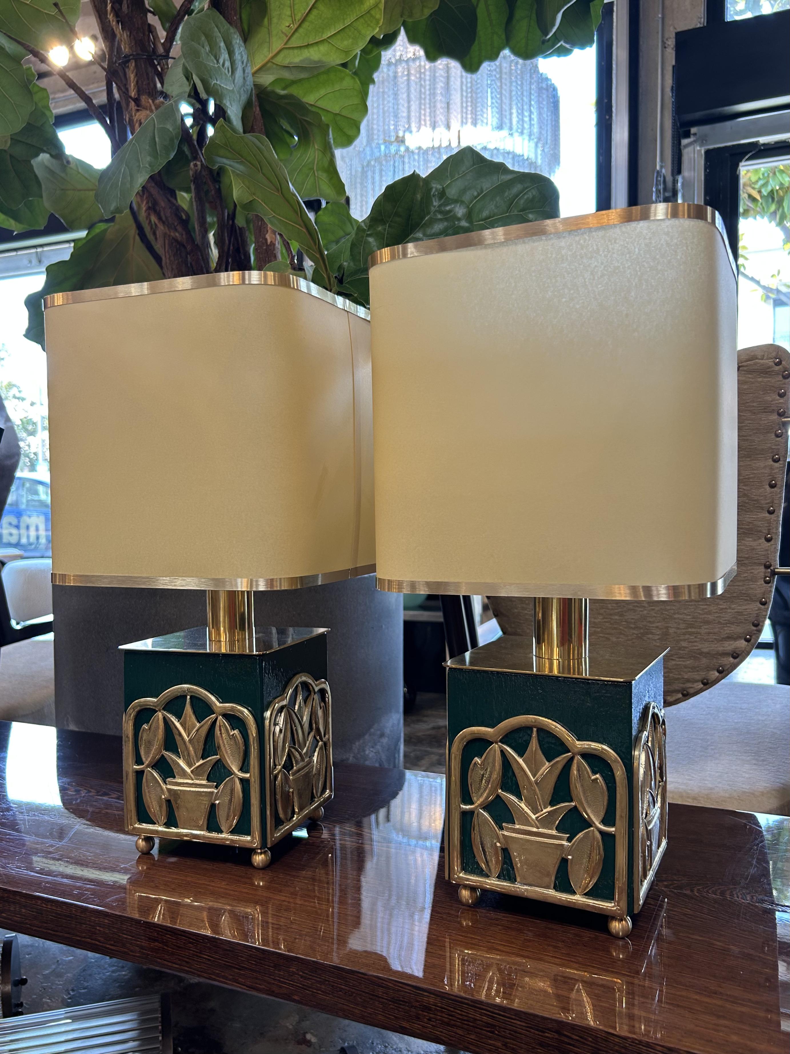 Beautiful pair of Italian table lamps, each crafted with a sculptural green lacquered base adorned by intricate gilt metal appliqués in the form of stylized potted plants. The botanical motif, both whimsical and architectural, is framed in softly