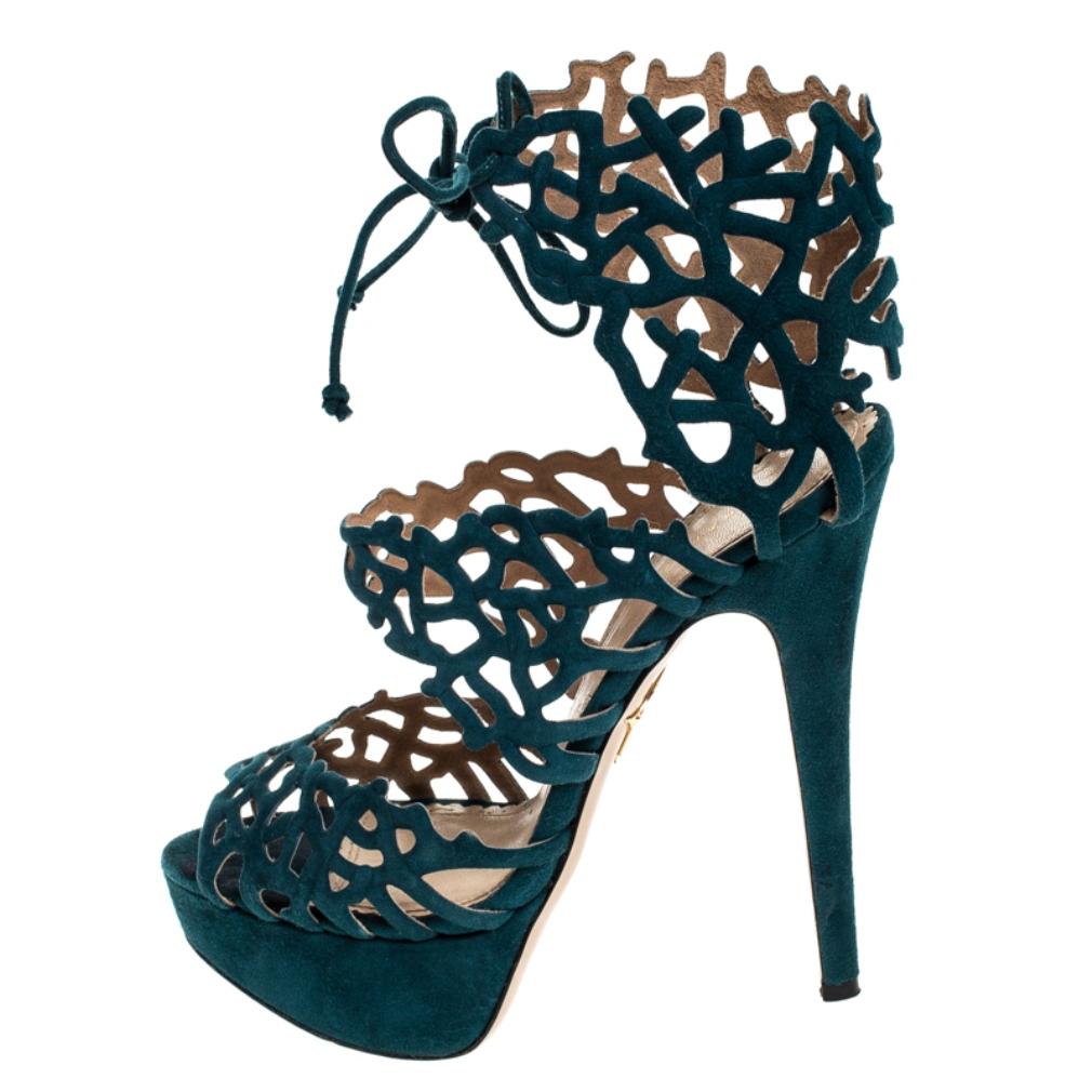 Adorned with a beautiful laser cut patterned design all through the front, these Charlotte Olympia peep-toe platform sandals are sure to add a stylish touch to your day and night time special looks. Constructed in green suede all over, these shoes