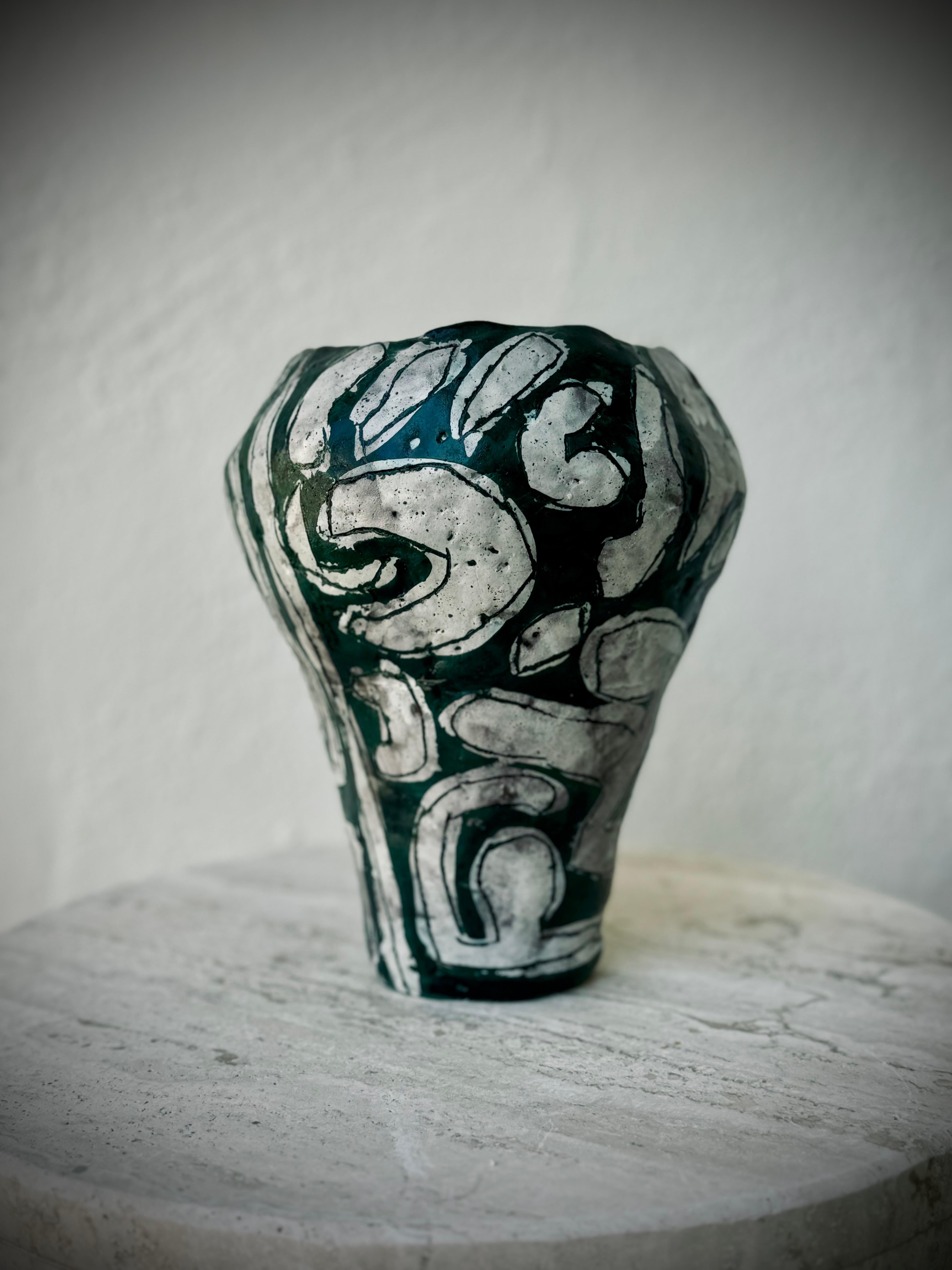 Con un cenno alla spontaneità e all'imperfezione privilegiata che è la condizione umana, tutti i miei pezzi infondono un'energia di funzionalità e capriccio.

Il vaso in ceramica Greene Lava 1 è caratterizzato da una sensazione di fusione, grazie a