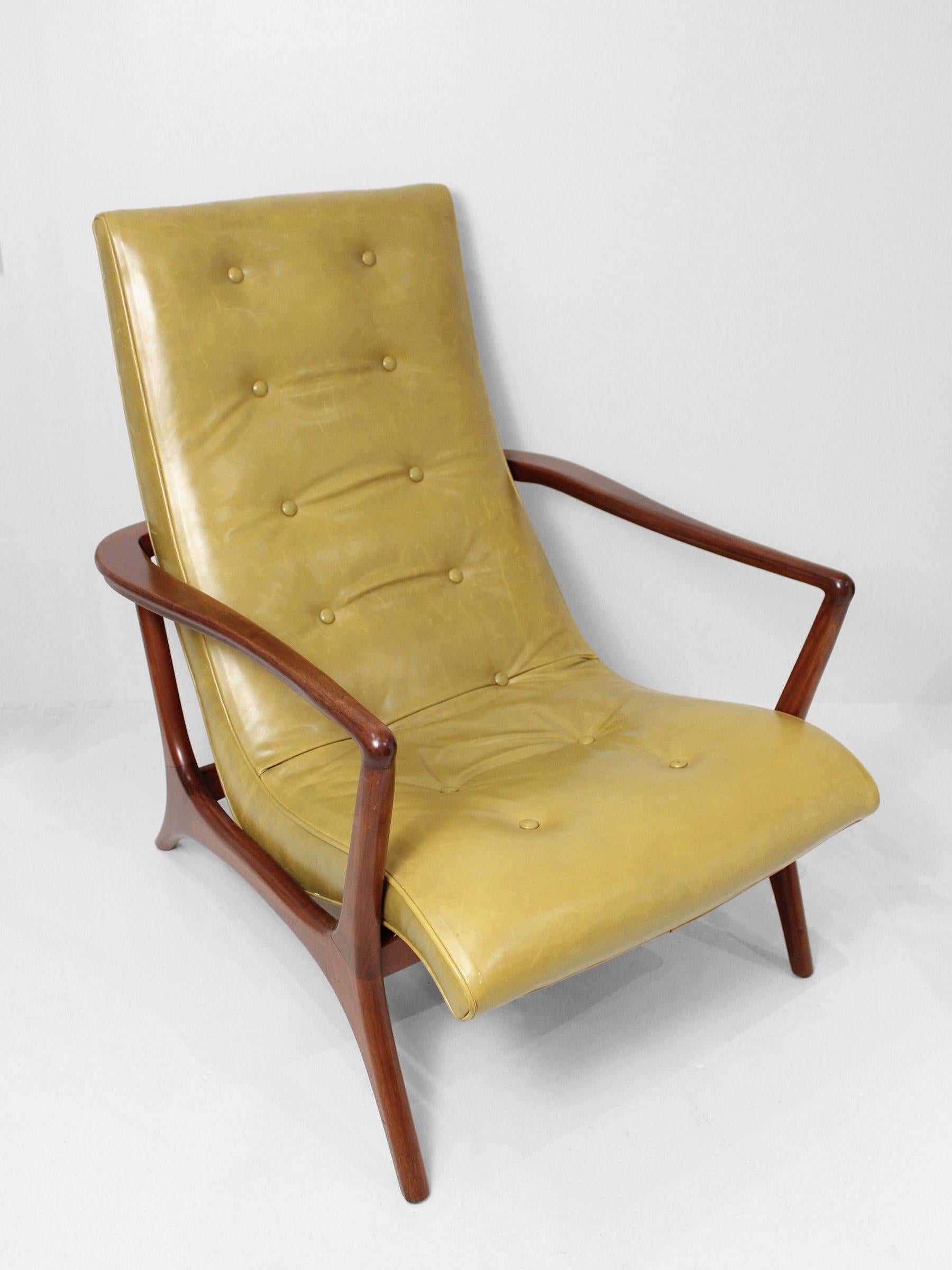 A handcrafted walnut wood and green leather arm chair. This vintage chair features beautiful leather and excellent woodwork with curved contours and sleek finishes, creating a sculptural composition is also designed for comfort.