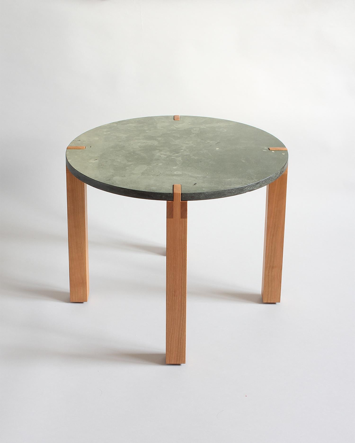 Green limestone top with a honed finish notches into intricately joined solid cherry base. This piece is made and ready to ship from Los Angeles. Solid American Cherry is hand selected from a family run lumber yard for clarity and aesthetics. 
The