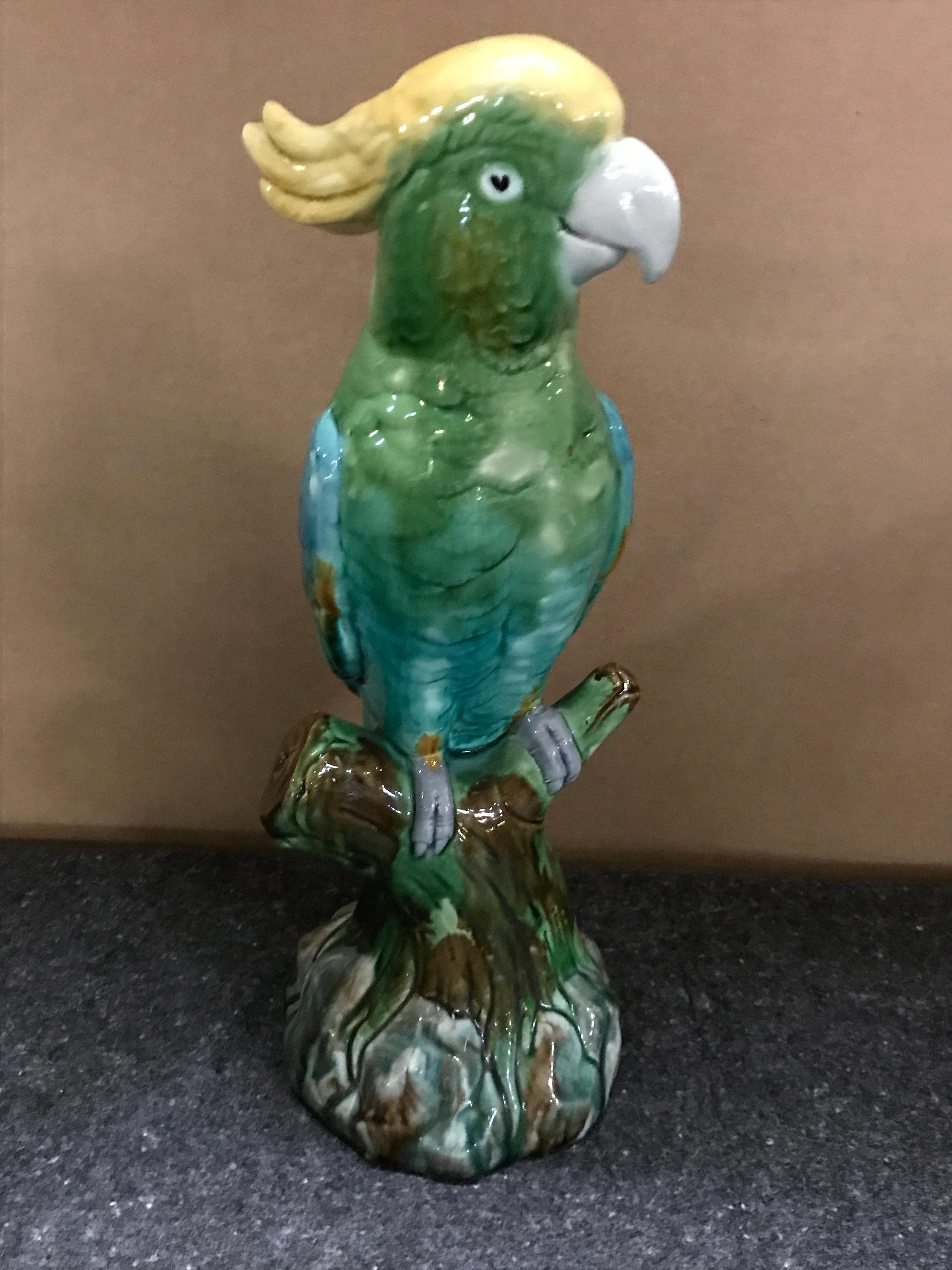 Green Majolica parrot by Mintons, realistically modeled seated on a branch on a rockwork base.

 