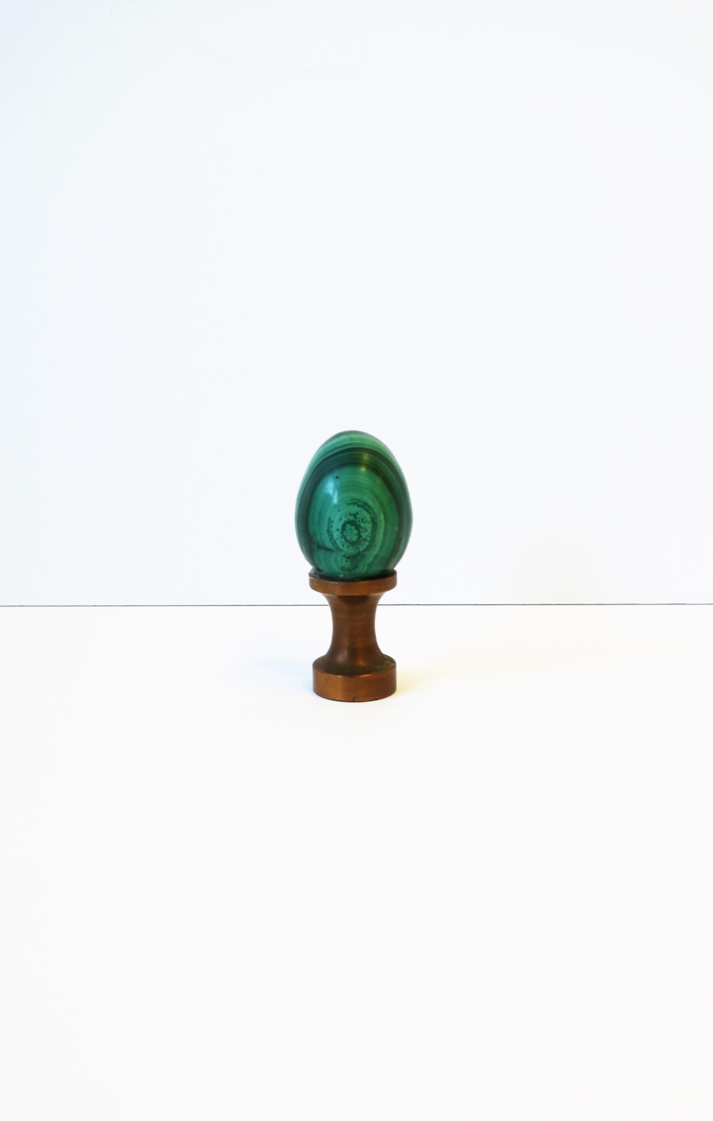 A small and beautiful green Malachite egg on copper base decorative object, circa 20th century. A green Malachite piece in egg shape form, polished smooth, adhered to a solid copper base. Piece is relatively small but substantial given its